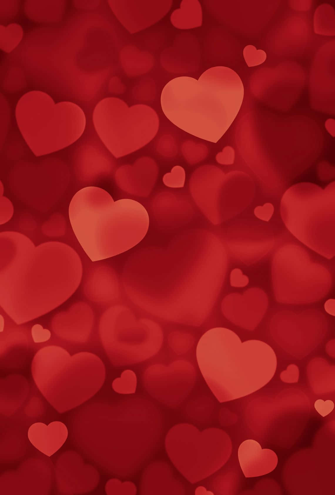 Red Hearts 桌布 壁紙 — 一個柔和焦點的區域，充滿了不同大小的發光紅色心形，營造出夢幻浪漫的氛圍。