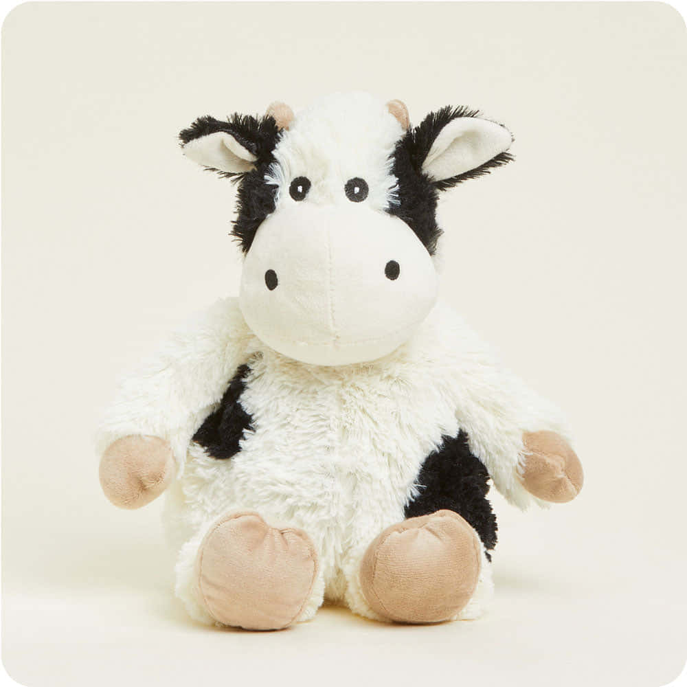 Black And White Cow 桌布 壁紙 — 一個柔軟毛絨的黑白乳牛玩偶，直立在純米白色背景前。