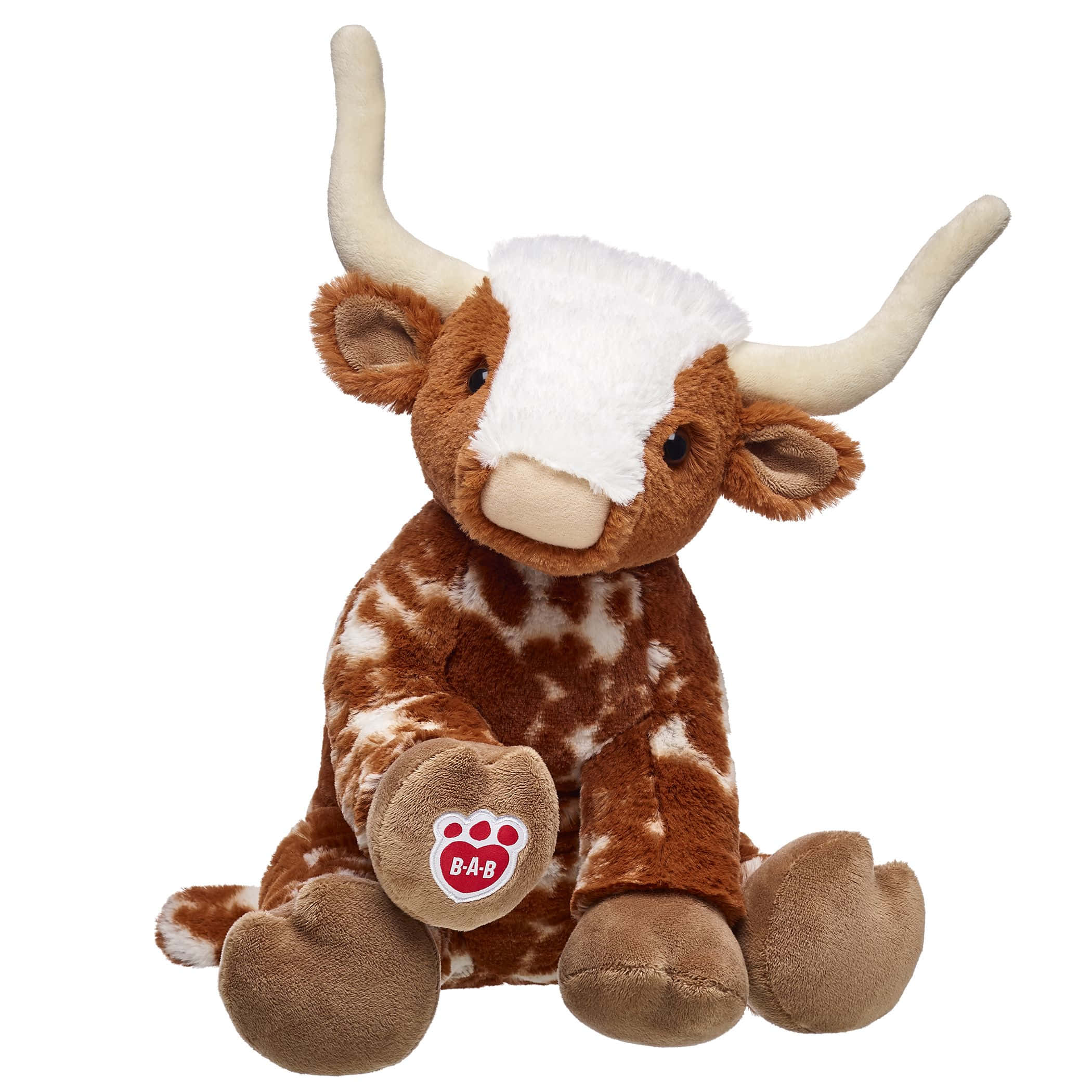 Longhorn 桌布 壁紙 — 一個柔軟的棕色和白色長毛牛毛絨玩具直立坐在乾淨的白色背景前。