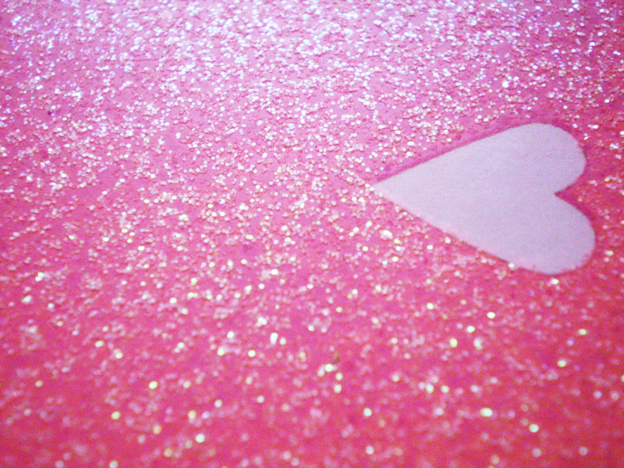 Glitter Pink Hearts 桌布 壁紙 — 一個柔軟的白色心形放在充滿活力的粉紅色閃粉表面上，閃爍著光芒。