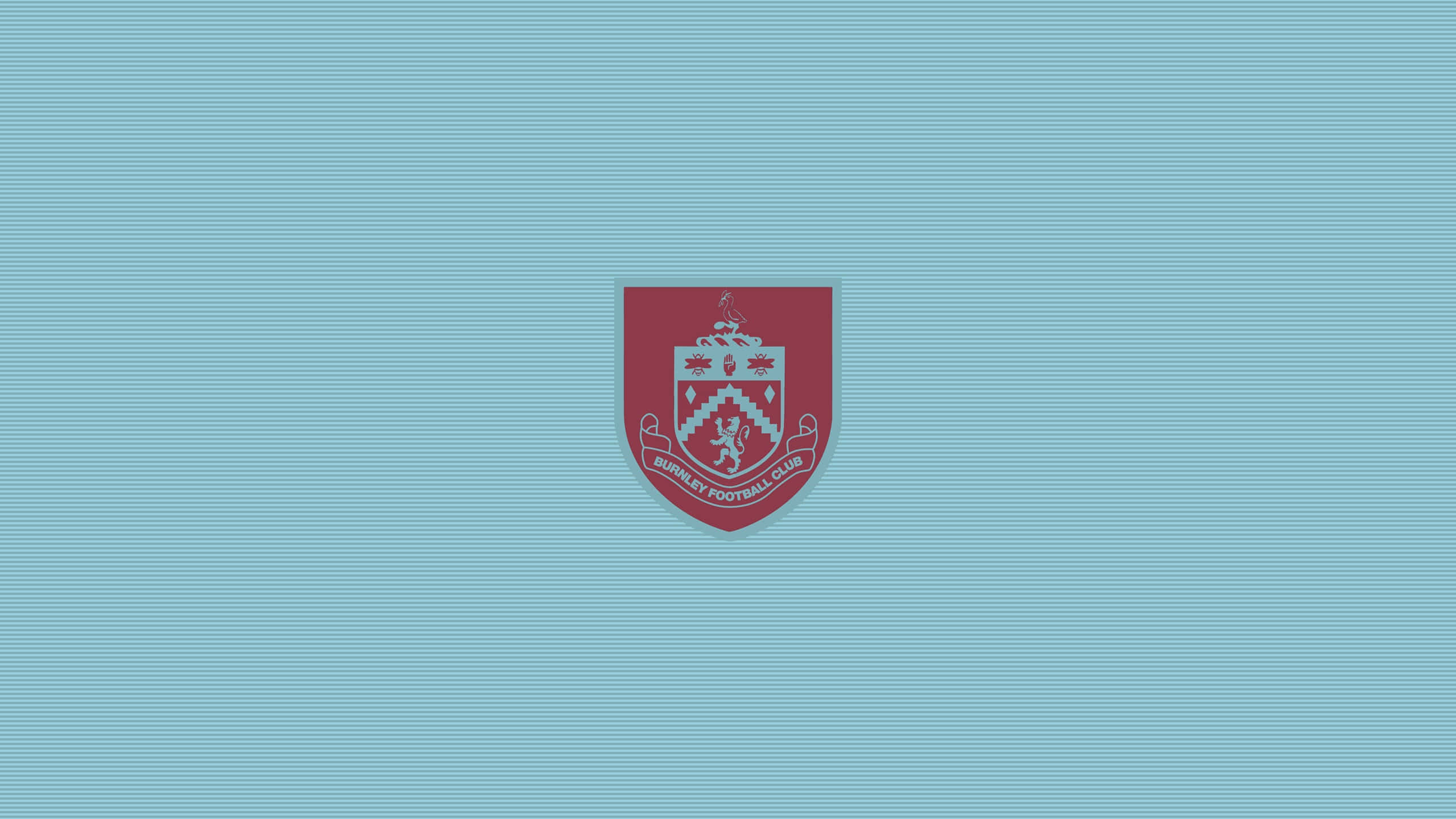 Burnley Fc 桌布 壁紙 — 一個栗色般尼足球俱樂部徽章，置中於帶有微妙橫紋的淺藍色背景上。