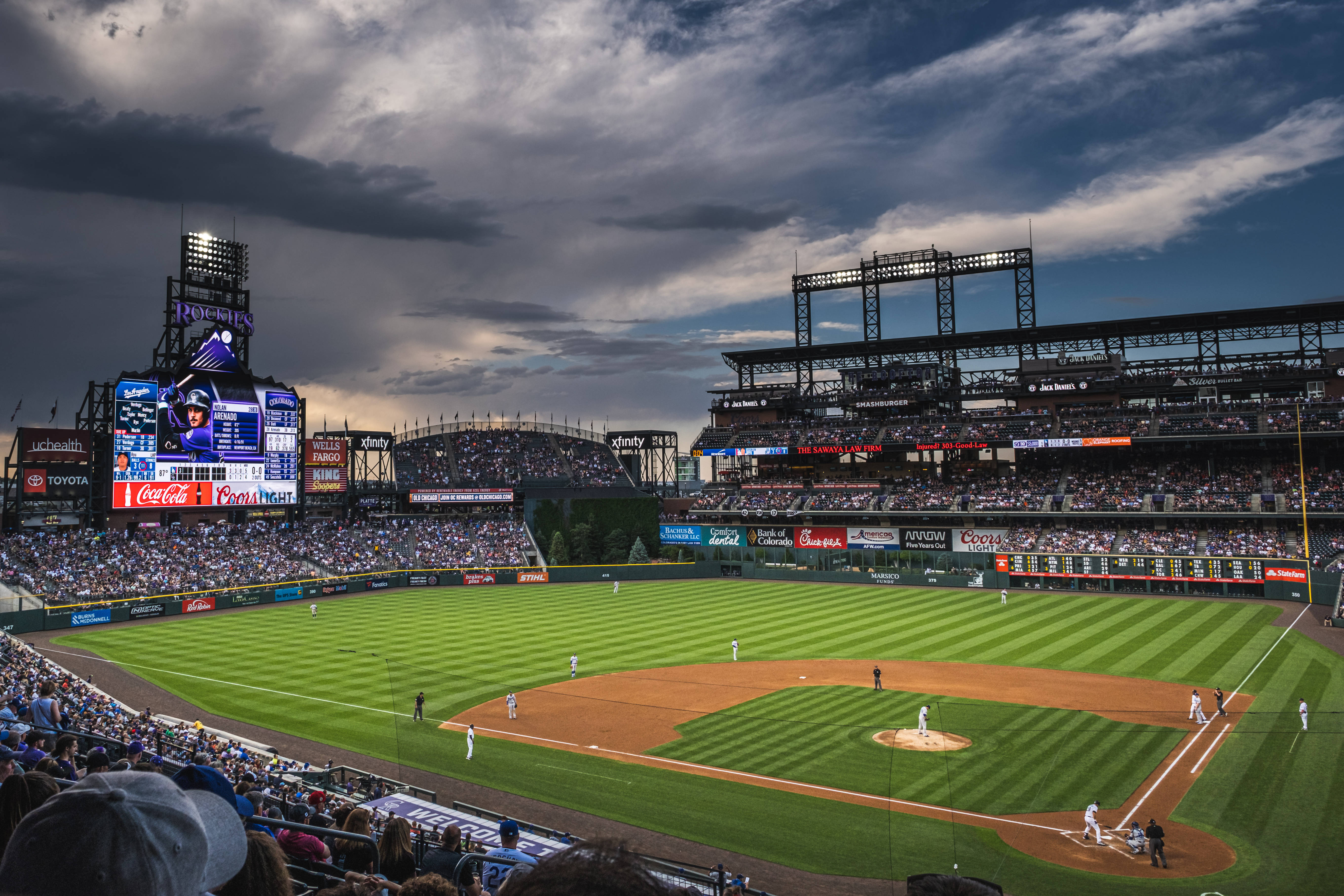 MLB 桌布 壁紙 — 一個棒球場在黃昏比賽期間，充滿了球迷，頭頂是戲劇性的暴風雲。