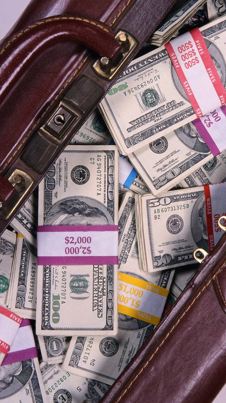 money iPhone 桌布 壁紙 — 一個棕色皮革公事包，塞滿了不同面額的美鈔。