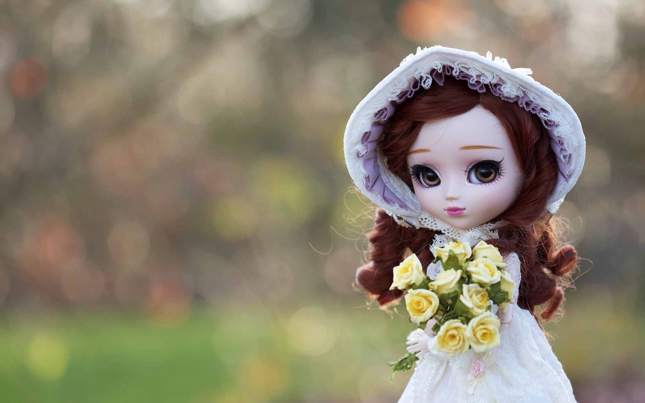Doll 桌布 壁紙 — 一個棕色頭髮、大眼睛的洋娃娃，戴著白色帽子，手持一束黃玫瑰，背景是柔和模糊的花園。