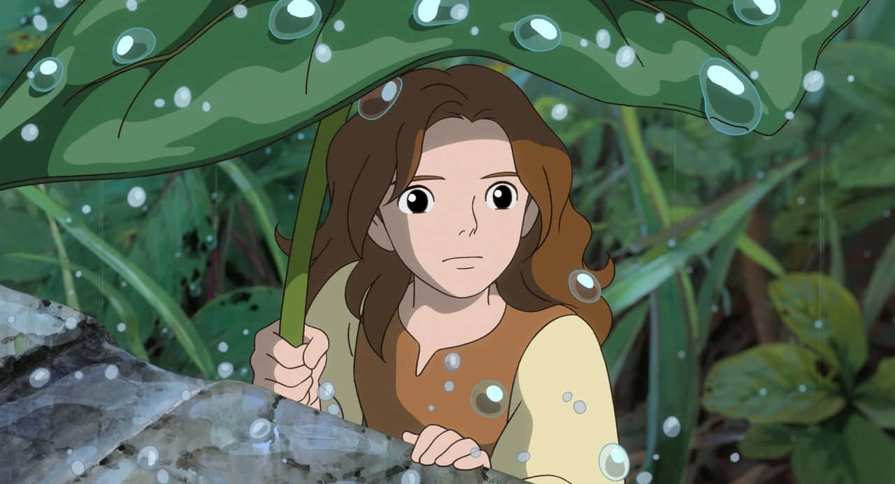 The Secret World Of Arrietty 桌布 壁紙 — 一個棕色頭髮的小女孩在茂密的森林中，拿著一把巨大的綠色樹葉傘，周圍有雨滴落下。