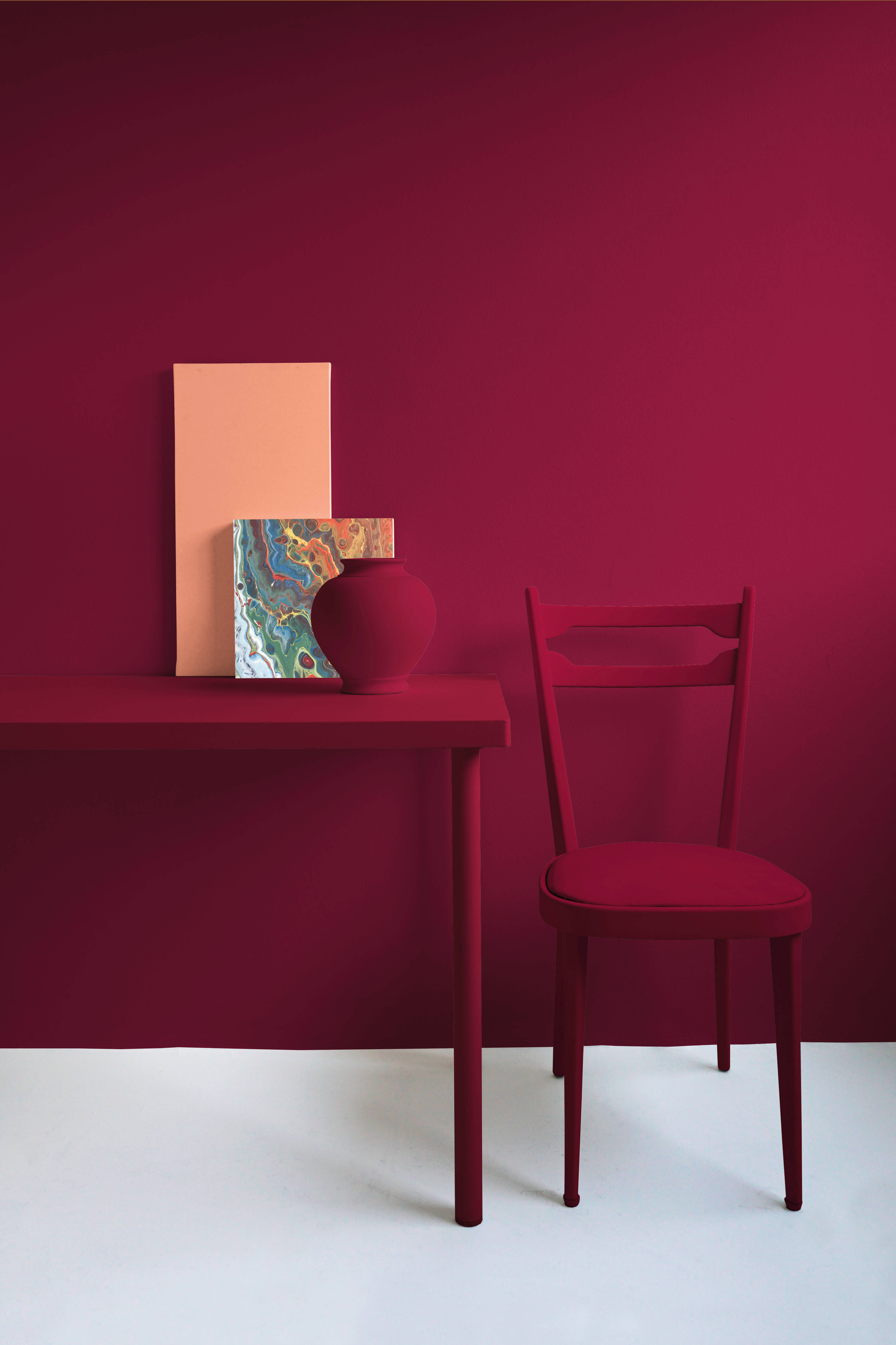 Interior Design 桌布 壁紙 — 一個極簡主義的室內場景，深紅色椅子與配套桌子，背景是鮮明的紅色牆壁，並以色彩繽紛的抽象花瓶和蜜桃色畫布點綴。
