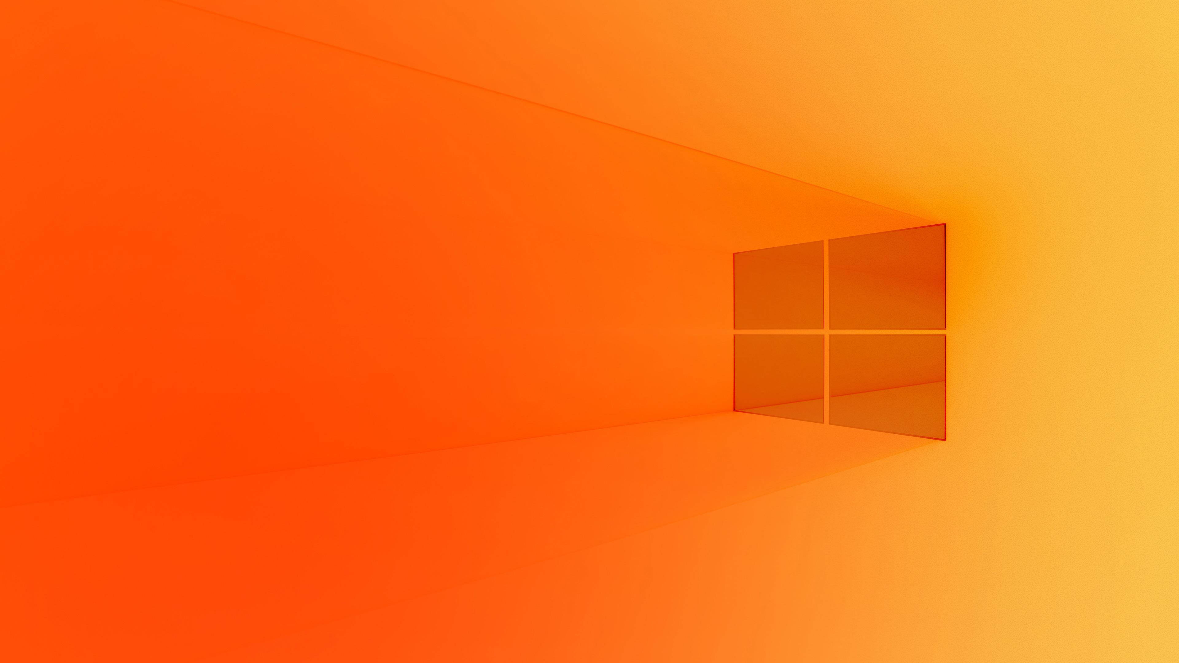 Windows 10 桌布 壁紙 — 一個極簡主義的數位藝術場景，包含一個發光的橙色漸變房間和一個投射柔和光線的Windows標誌窗戶。
