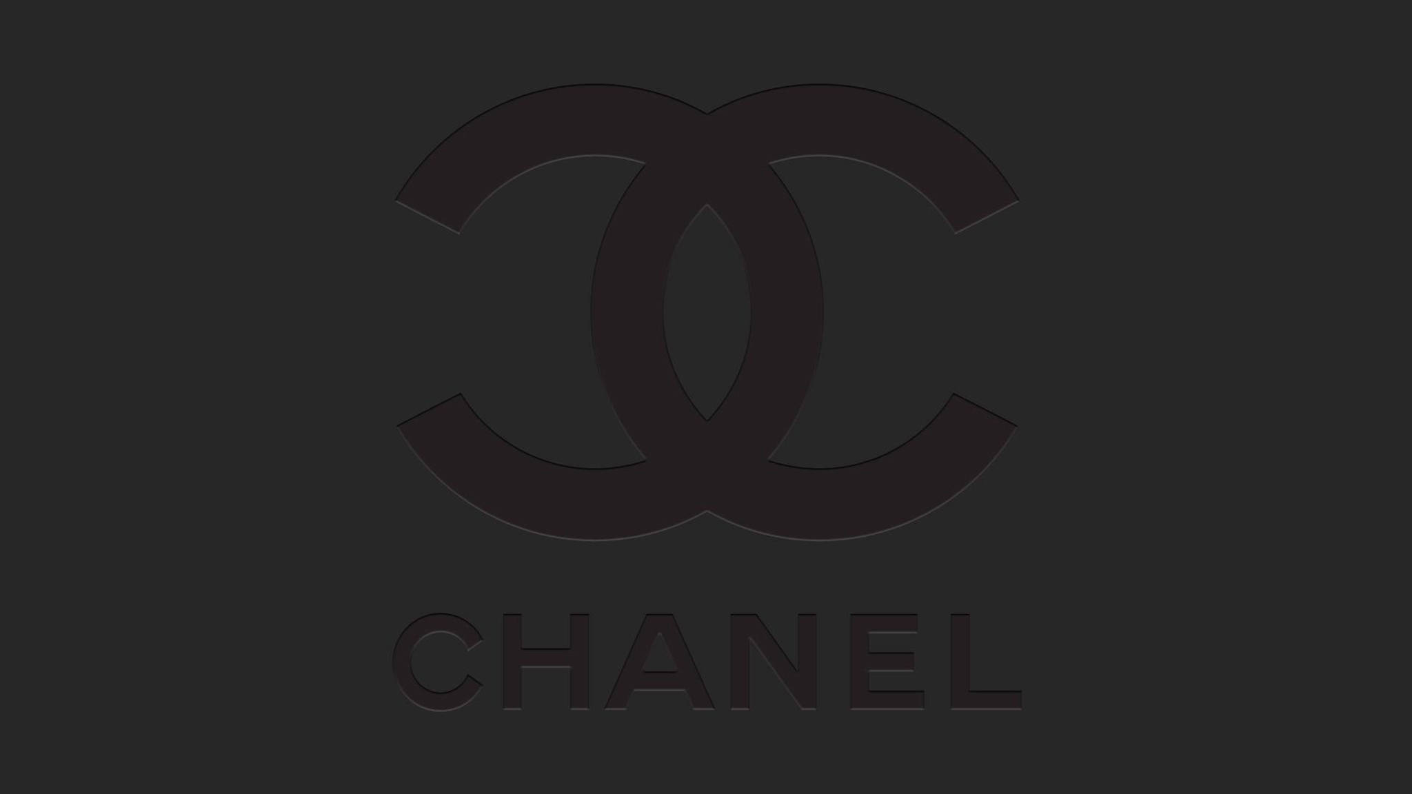 香奈兒標誌 桌布 壁紙 — 一個極簡主義的黑色Chanel標誌，帶有交織的C和品牌名稱，居中在深灰色背景上。