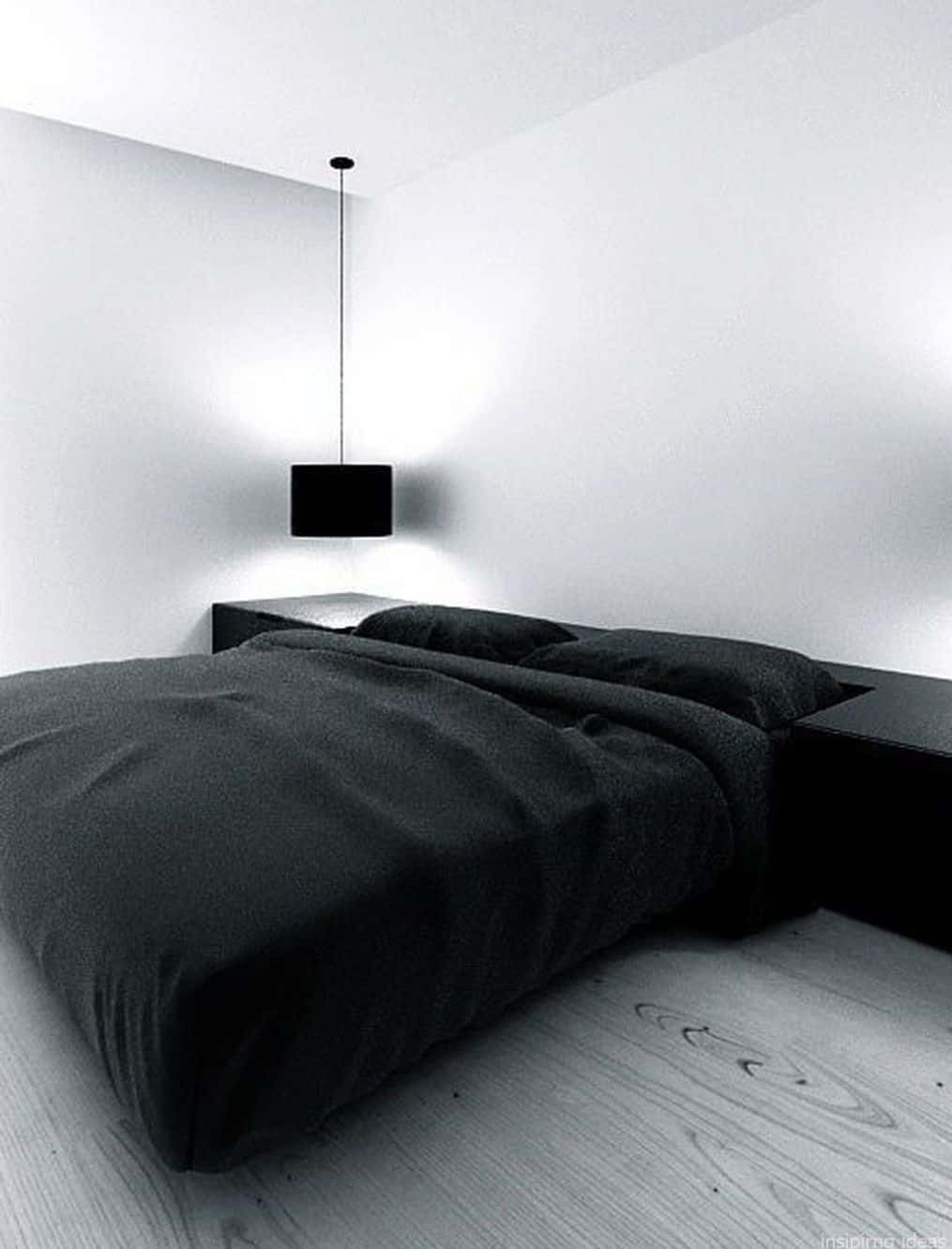 Minimalist Design 桌布 壁紙 — 一個極簡主義臥室，配有黑色床和懸浮吊燈，搭配純白牆壁和淺色木地板。