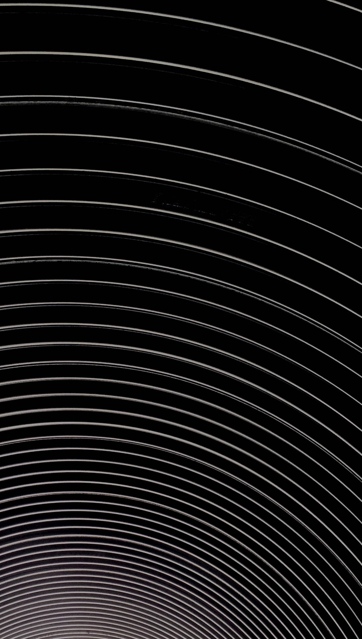 Hypnosis 桌布 壁紙 — 一個極簡抽象圖案，由深黑色背景上從明亮點放射出的同心白色弧線組成。