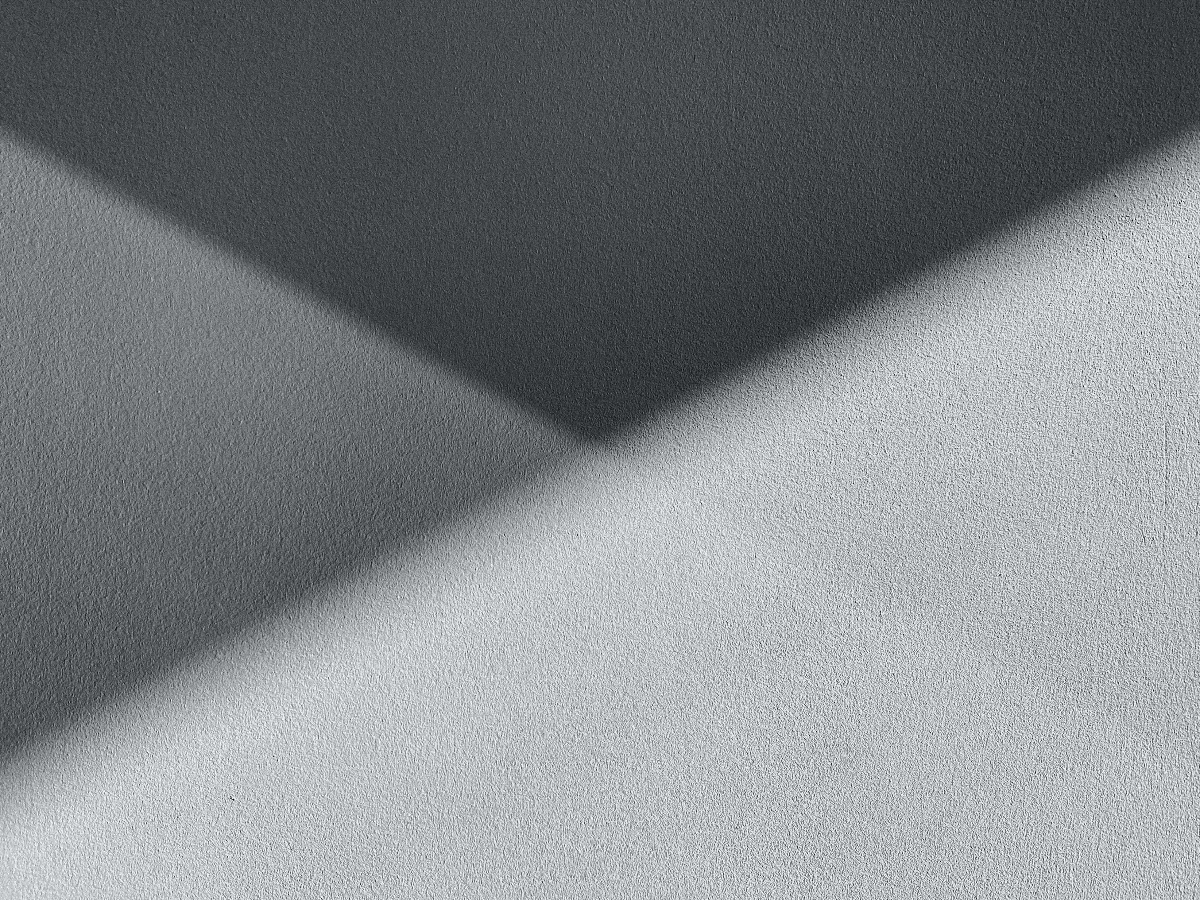 Gray Texture 桌布 壁紙 — 一個極簡抽象構圖，採用柔和的灰色調，並在紋理表面上呈現對角線光影漸變。