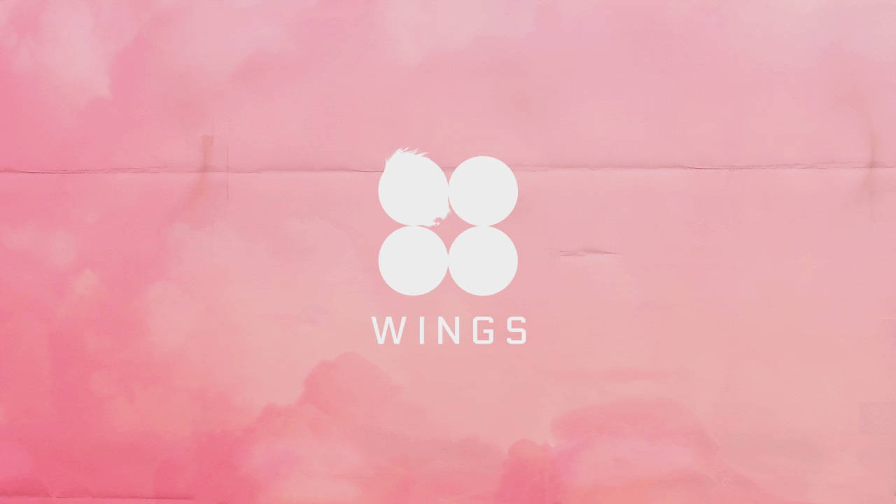 BTS 筆電 桌布 壁紙 — 一個極簡標誌，包含四個白色圓圈，中央有wings字樣，置於柔和粉紅水彩背景上。