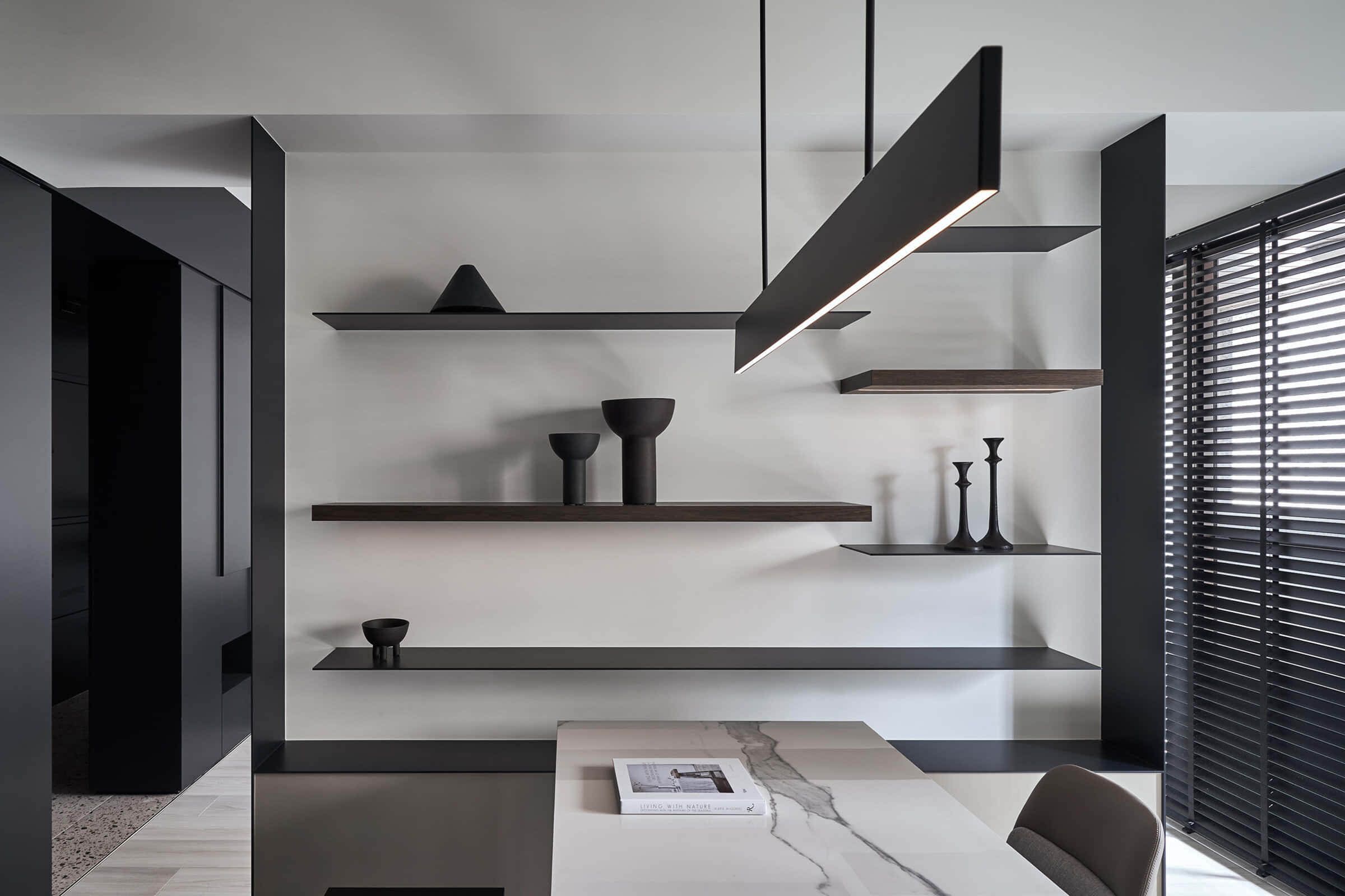 Minimalist Architecture 桌布 壁紙 — 一個極簡現代用餐區，設有黑色浮動層架，擺放簡約陶瓷花瓶，線性吊燈下配大理石餐桌。