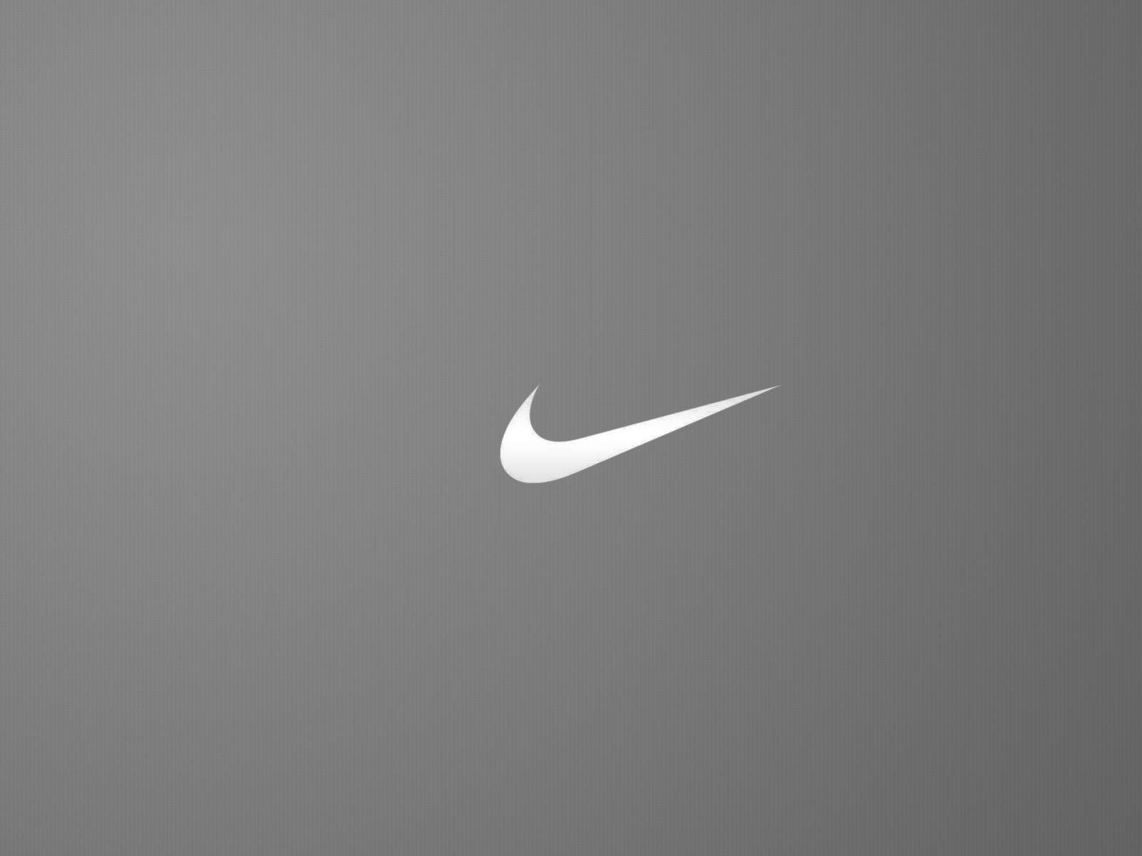 Nike 桌布 壁紙 — 一個極簡白色Nike swoosh標誌，居中在紋理灰色背景上。
