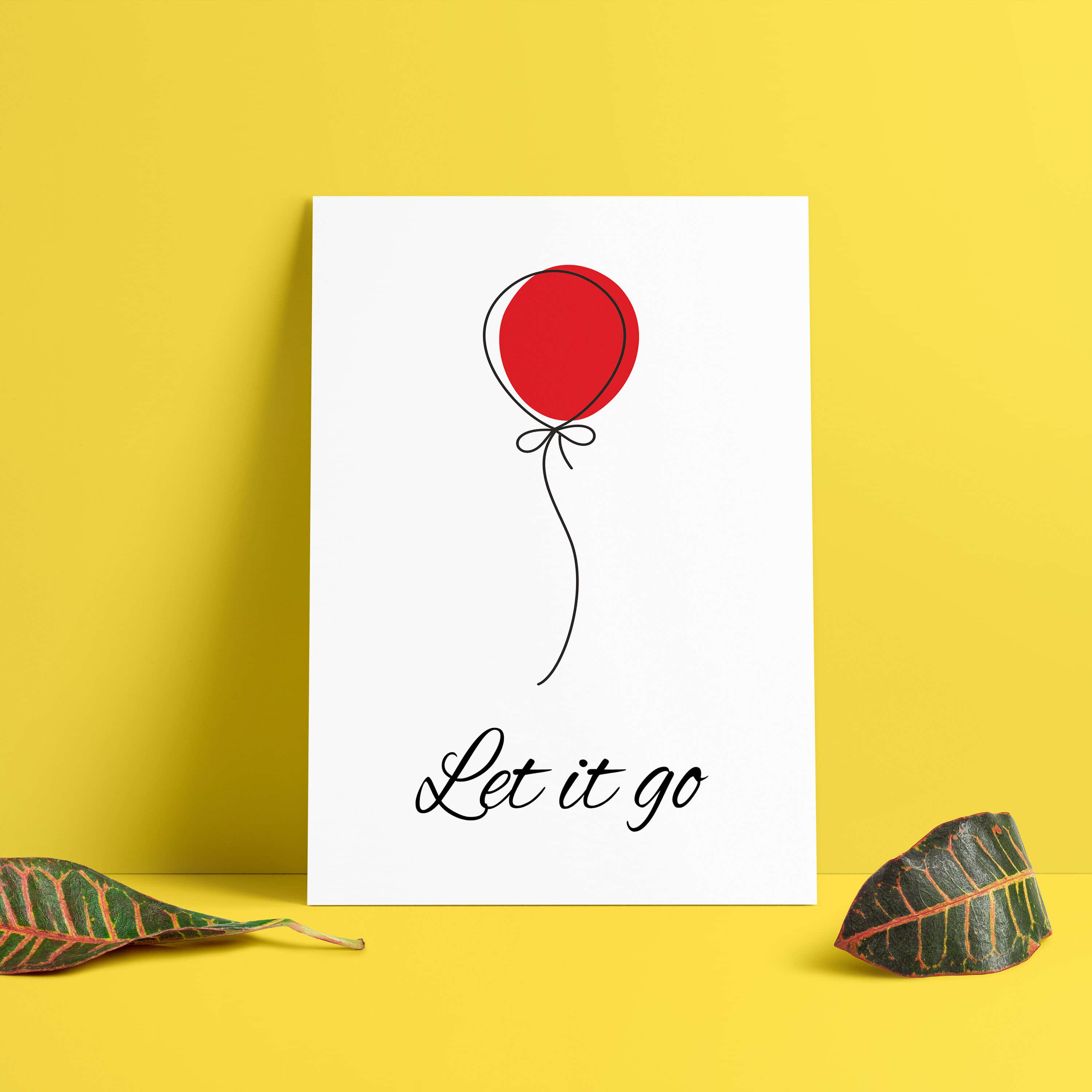 語錄 桌布 壁紙 — 一個極簡白色印刷品，上面有一個紅色氣球和「Let it go」文字，靠在一面鮮黃色的牆上，兩側有兩片圖案葉子。