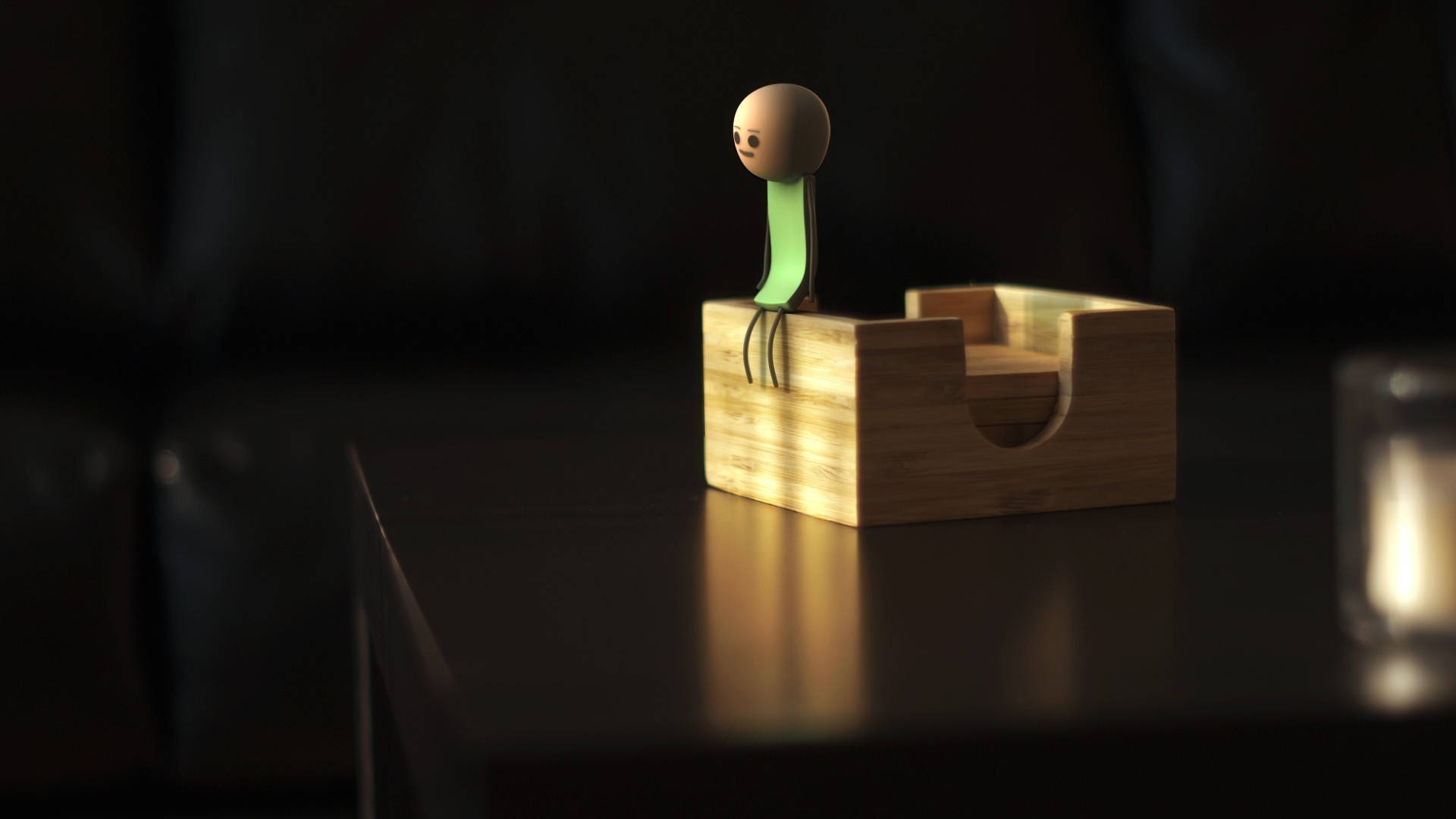 happiness 桌布 壁紙 — 一個極簡的3D渲染火柴人，綠色軀幹，坐在暗色桌子上的木箱上，處於溫暖的環境光中。