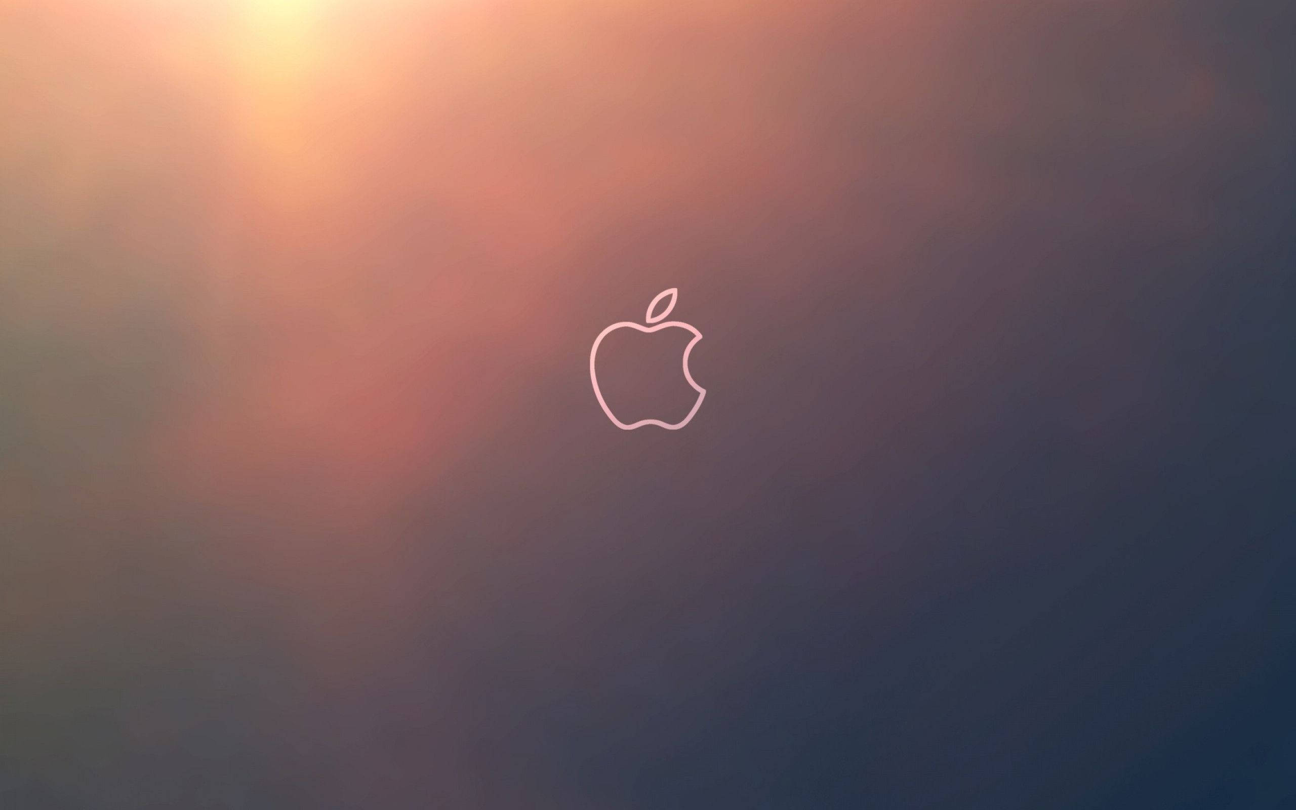 MacBook 動態圖片 桌布 壁紙 — 一個極簡的Apple標誌輪廓在漸變的日落天空中柔和發光，從溫暖的橙色過渡到深藍色。