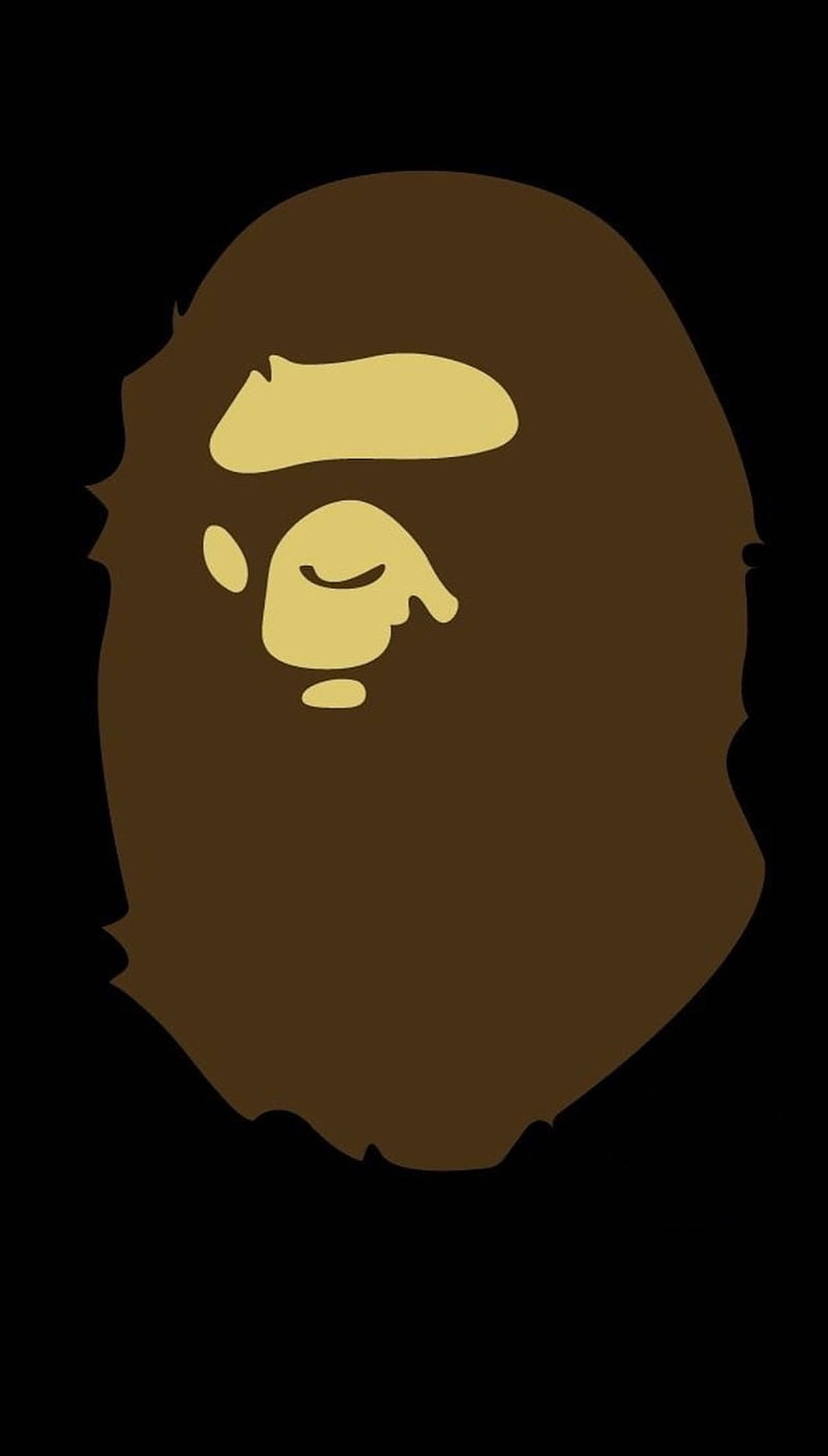 bape logo 桌布 壁紙 — 一個極簡的棕色猿頭標誌，帶有黃色面部特徵，在純黑色背景上脫穎而出。