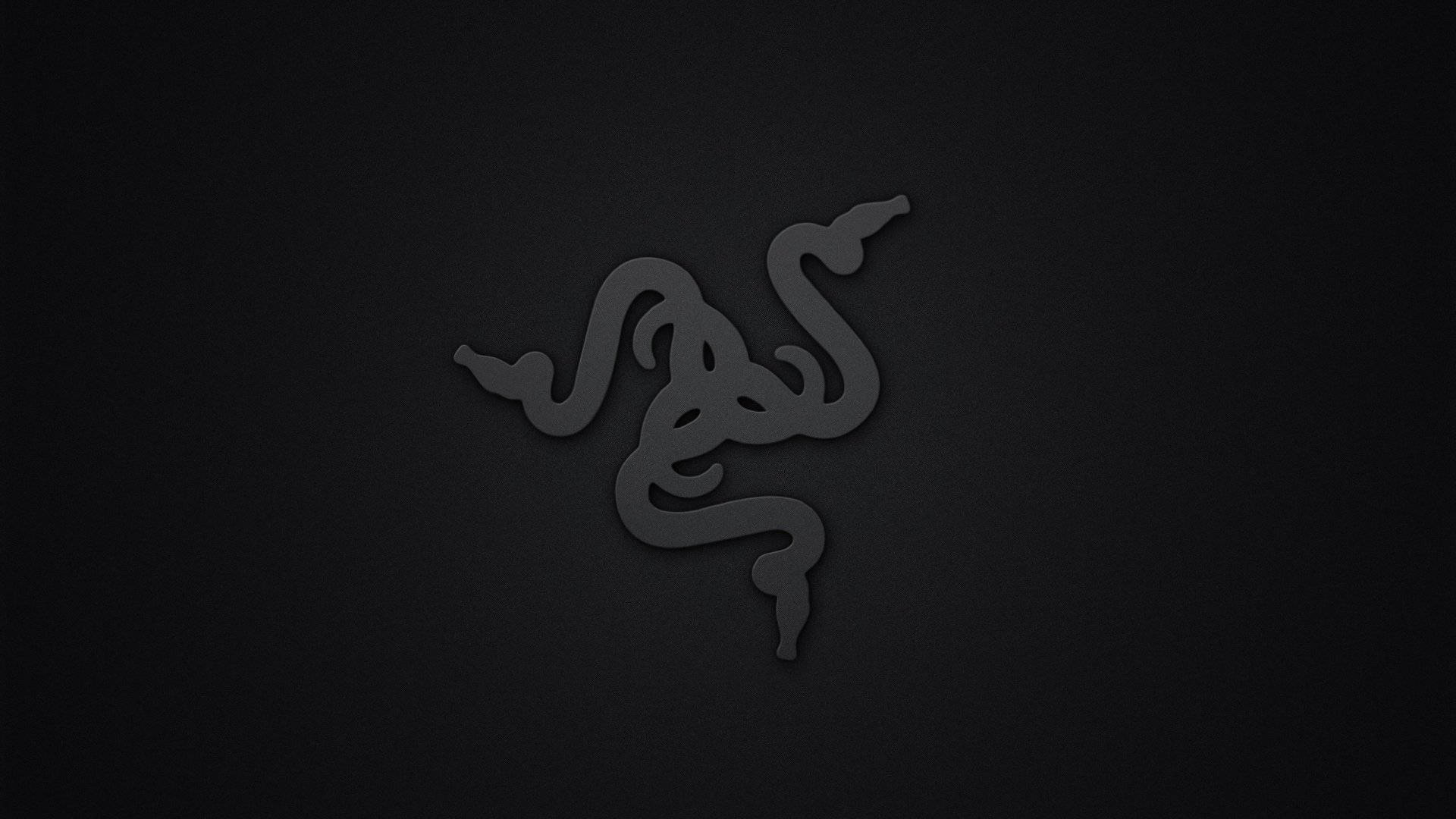 雷蛇電腦 桌布 壁紙 — 一個極簡的深灰色 Razer 標誌，微妙地壓印在帶有紋理的黑色背景上。