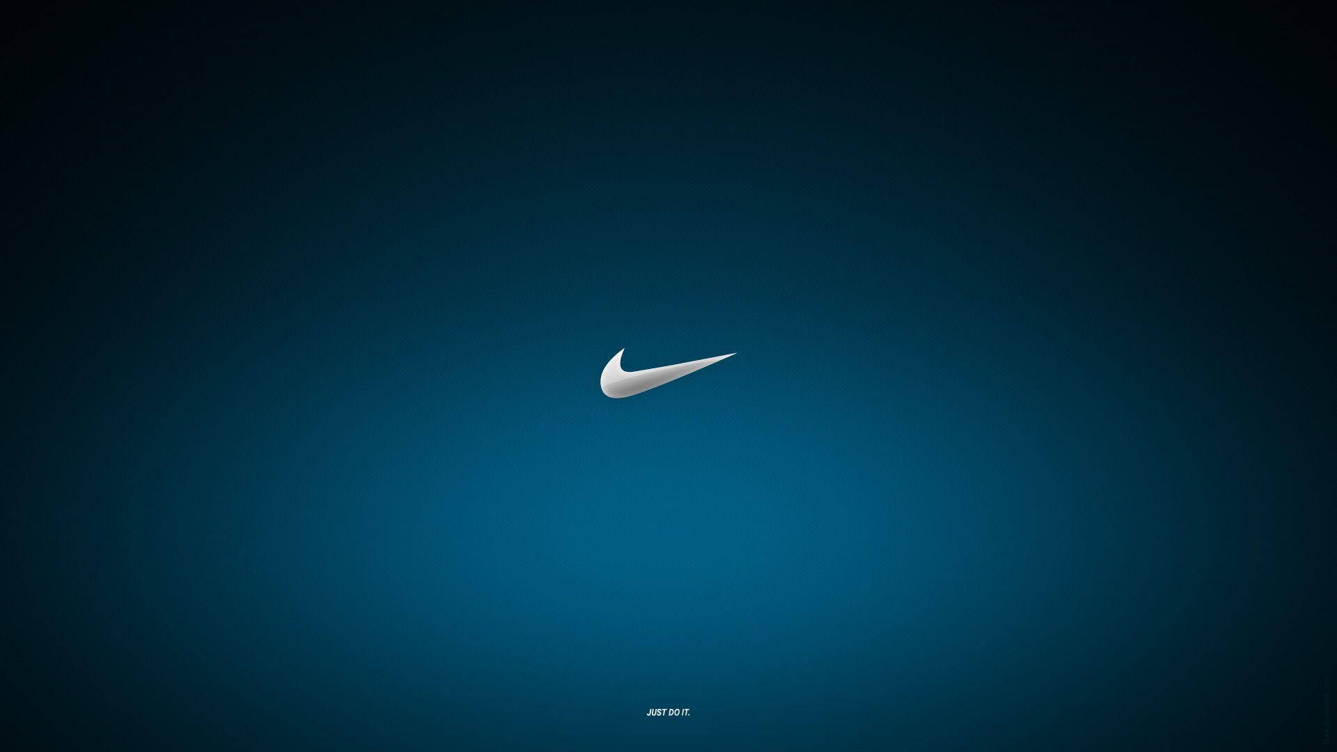 Cool Nike 桌布 壁紙 — 一個極簡的白色Nike swoosh標誌，居中放置在帶有微妙照明的漸變藍色背景上。