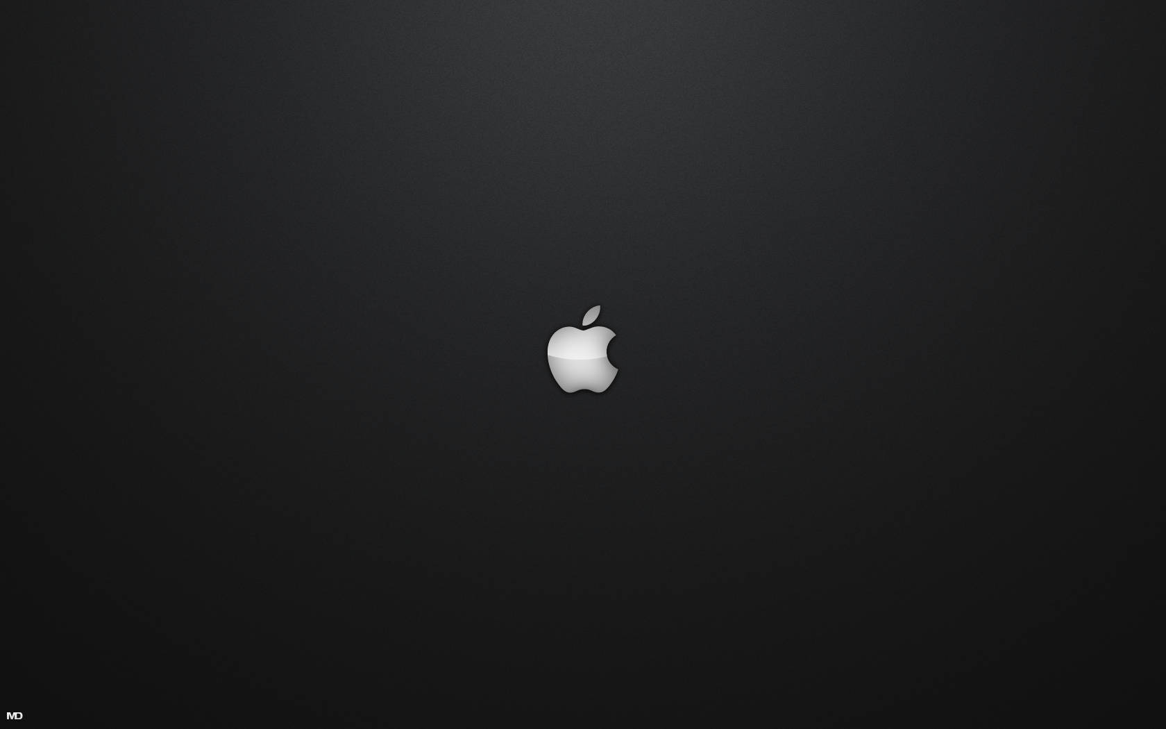 MacBook 動態圖片 桌布 壁紙 — 一個極簡的銀色Apple標誌，居中放置在帶有微妙照明的漸變黑色背景上。