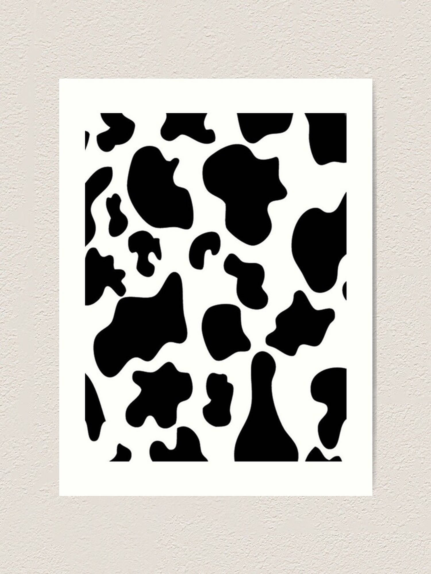 Print 桌布 壁紙 — 一個極簡的黑白乳牛圖案，白色背景，裱框在質感米色牆上。
