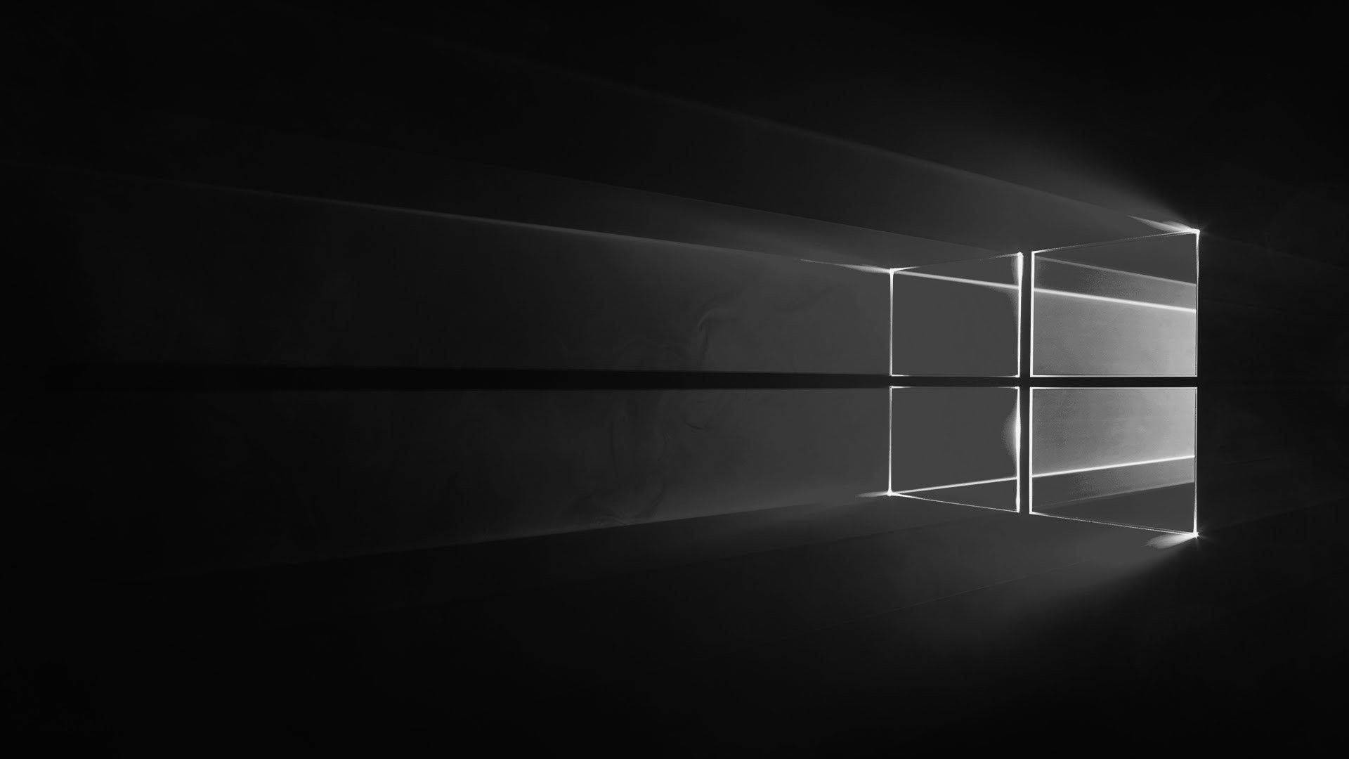 Windows 桌布 壁紙 — 一個極簡的黑白窗戶標誌，在黑暗虛空中被戲劇性的光線照亮。