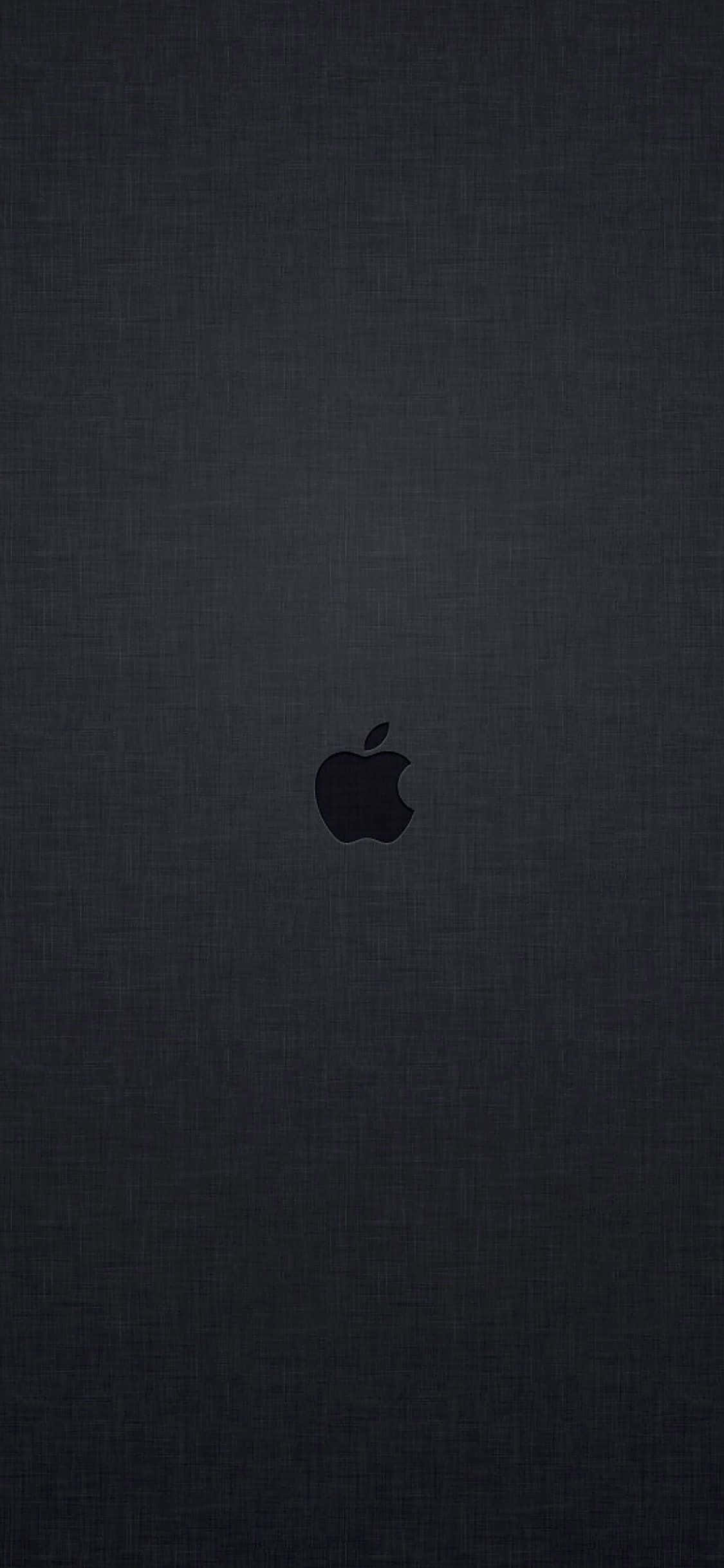 蘋果 桌布 壁紙 — 一個極簡的黑色Apple標誌，居中放置在深色紋理布料背景上。