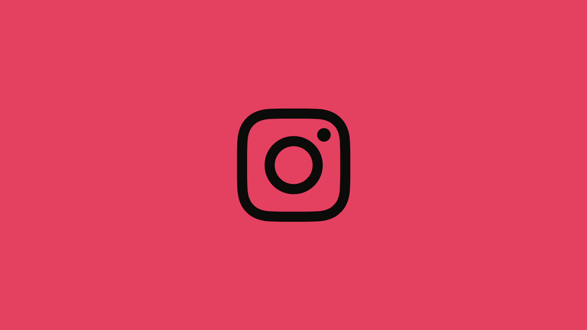 Instagram 桌布 壁紙 — 一個極簡的黑色Instagram標誌居中在純珊瑚粉紅背景上。