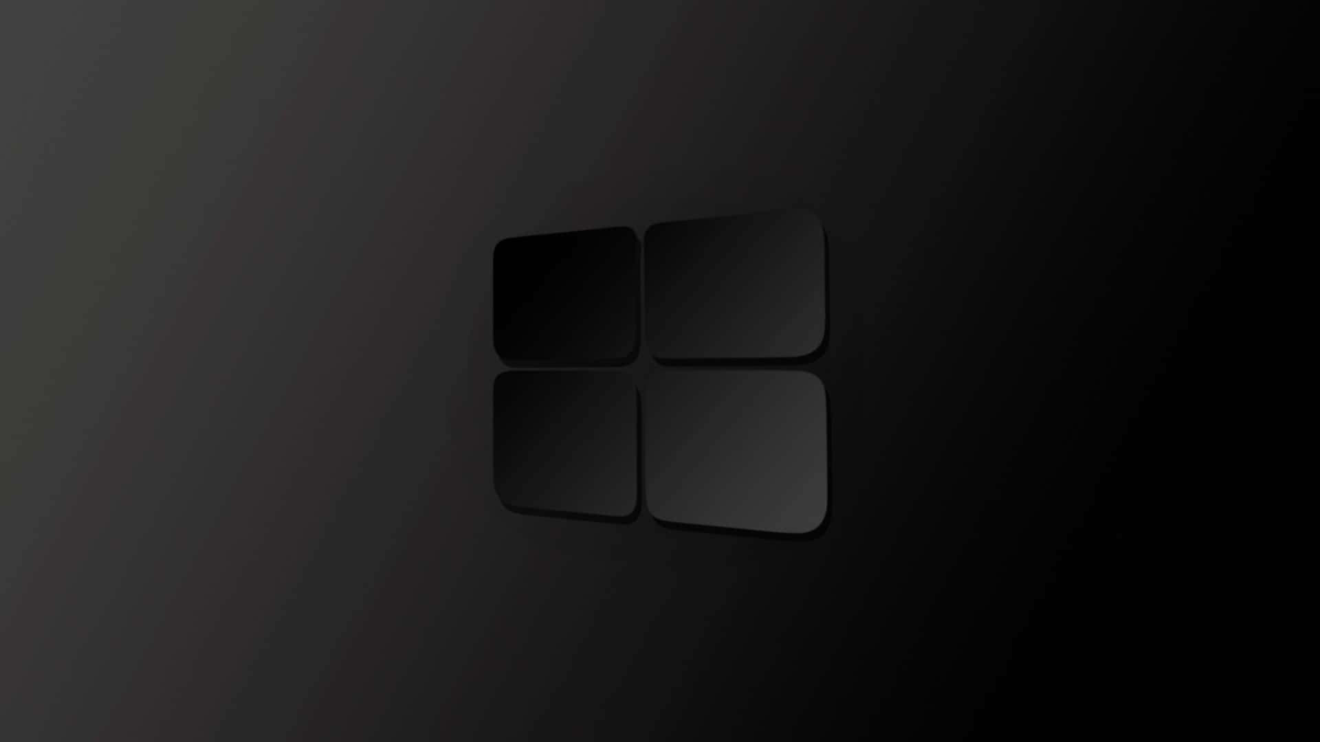 Black Windows 桌布 壁紙 — 一個極簡的黑色Microsoft標誌，帶有微妙的漸變陰影，居中放置在深色漸變背景上。