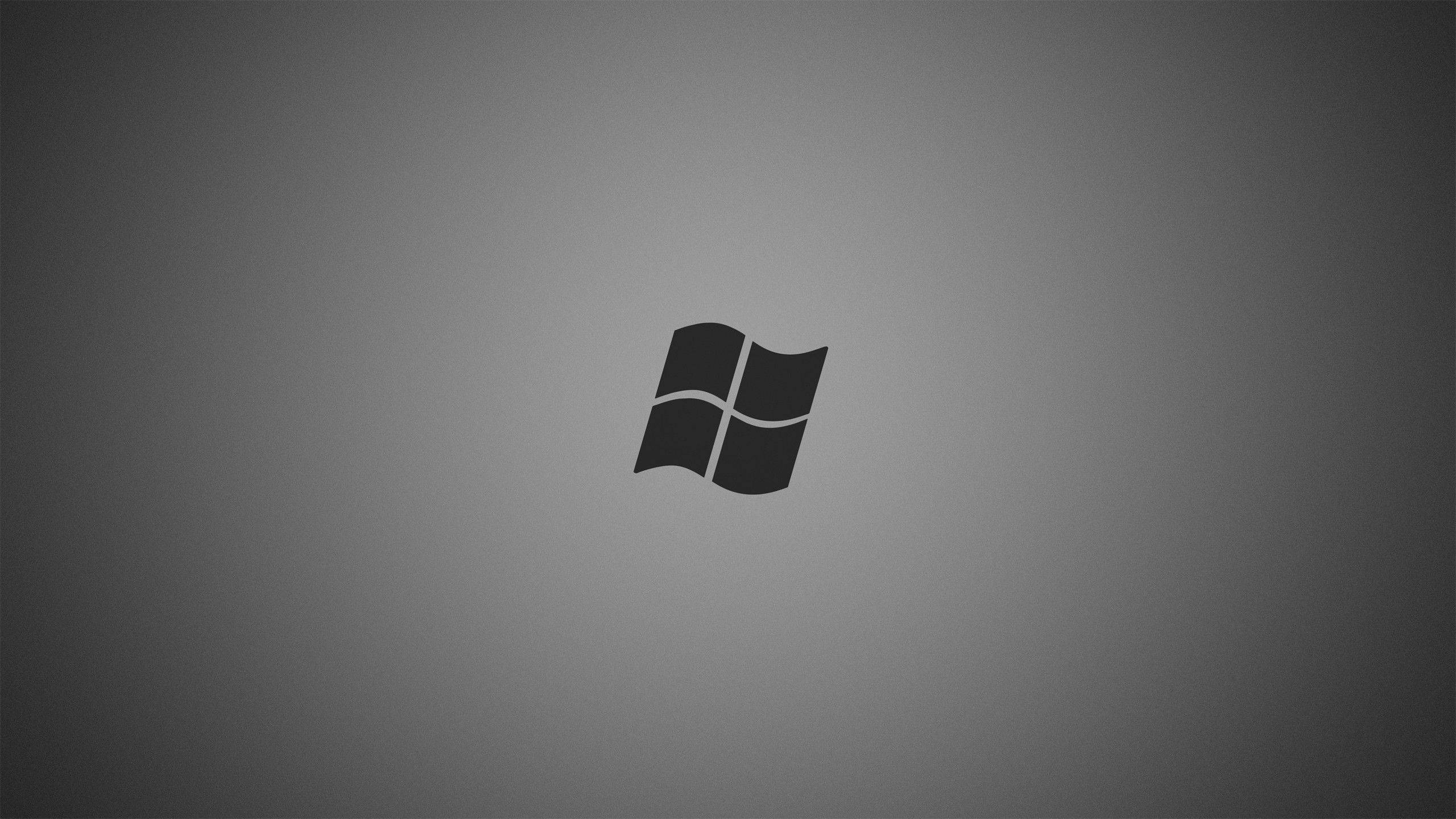 Dark Windows 桌布 壁紙 — 一個極簡的黑色Windows標誌居中在柔和的漸變灰色背景上。