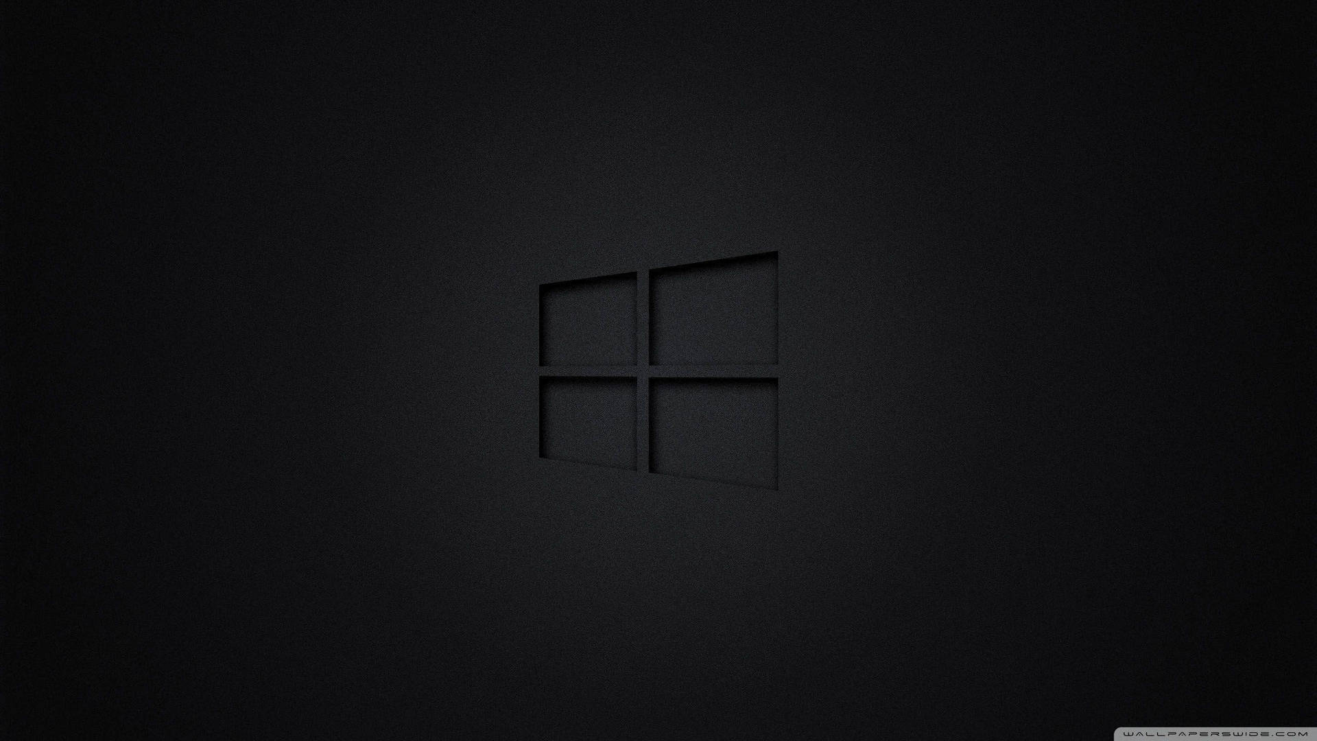 Windows標誌壓印在霧面深色表面上，柔和燈光