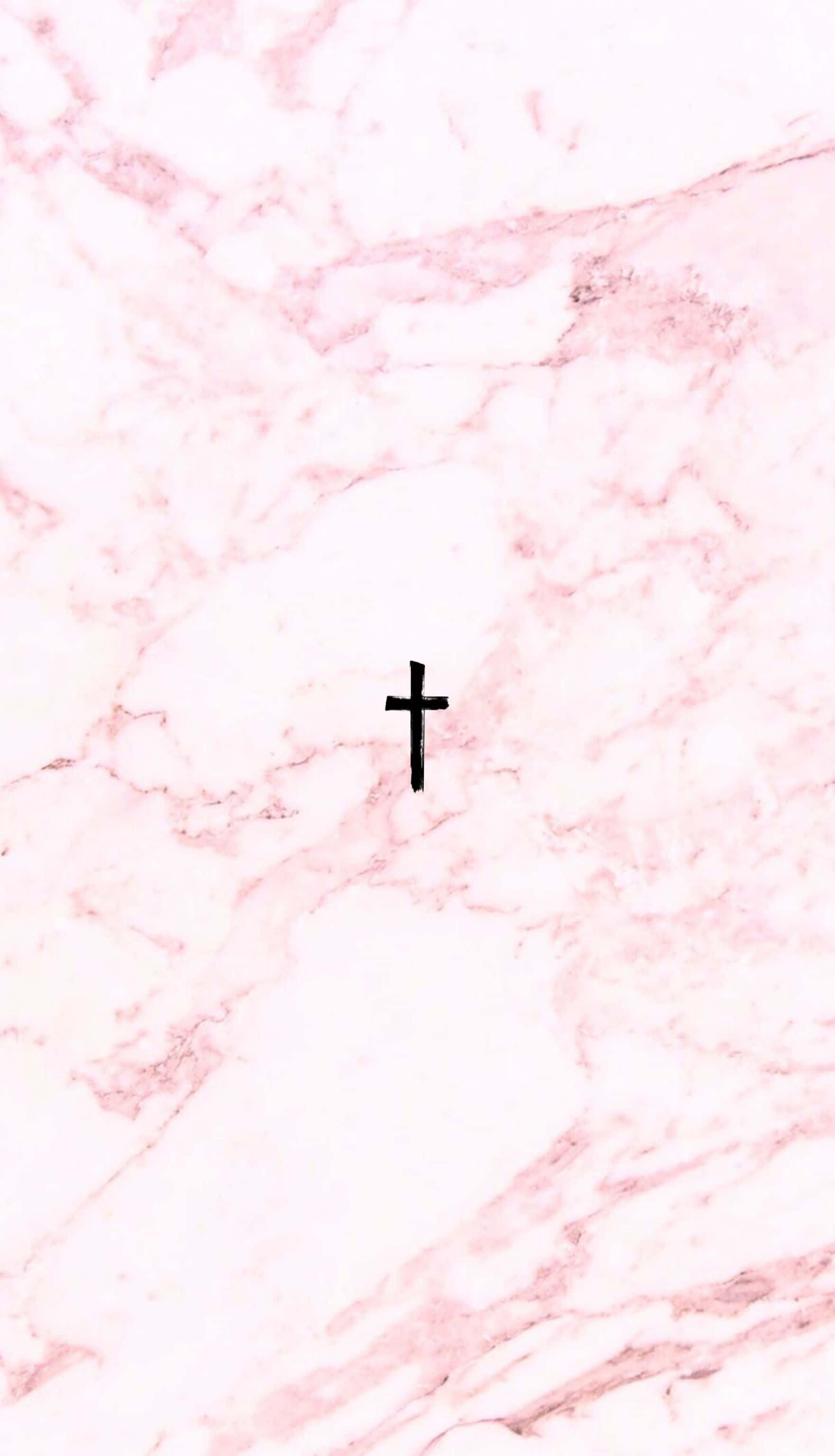 Pink Cross 桌布 壁紙 — 一個極簡的黑色十字架，置中於柔和的粉紅與白色大理石背景上。