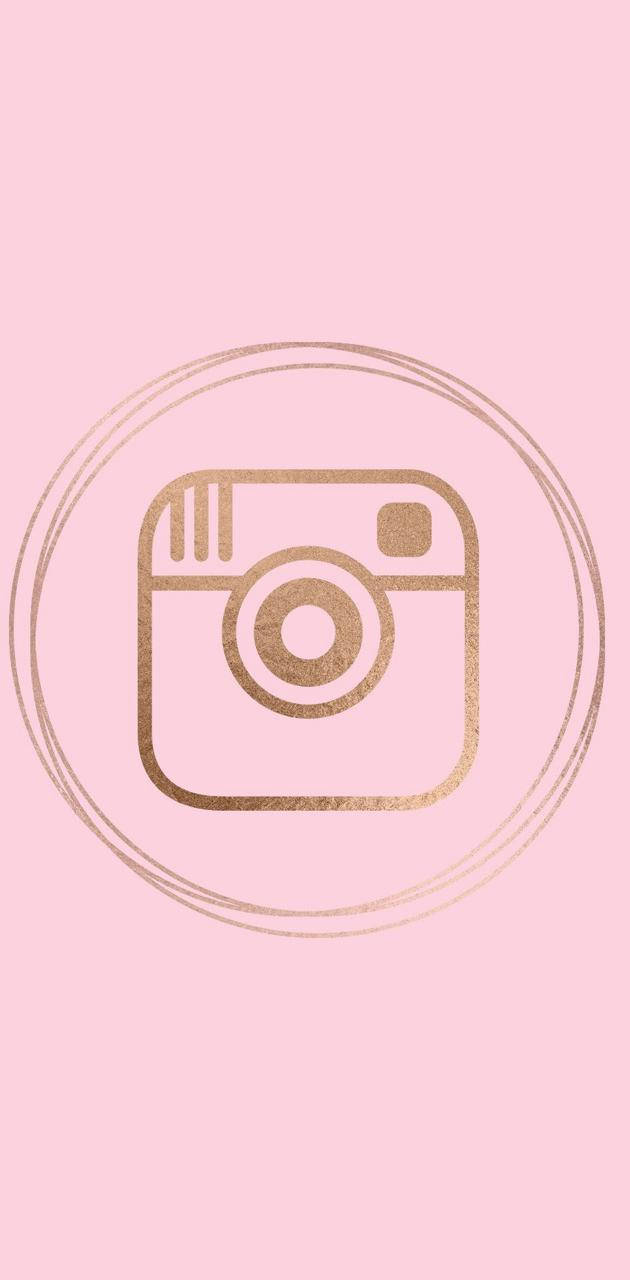Cute Instagram 桌布 壁紙 — 一個極簡金色閃粉Instagram標誌，居中於雙圓圈內，背景為柔和粉紅色。