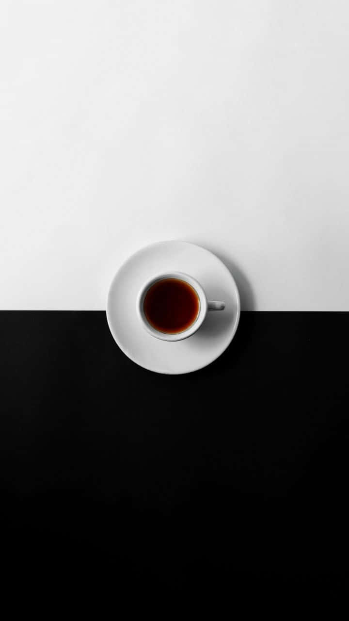 Minimalist Black And White 桌布 壁紙 — 一個極簡風格的俯拍鏡頭，拍攝一隻白色茶杯盛載深色茶，放在茶碟上，置於黑白分明的背景中央。