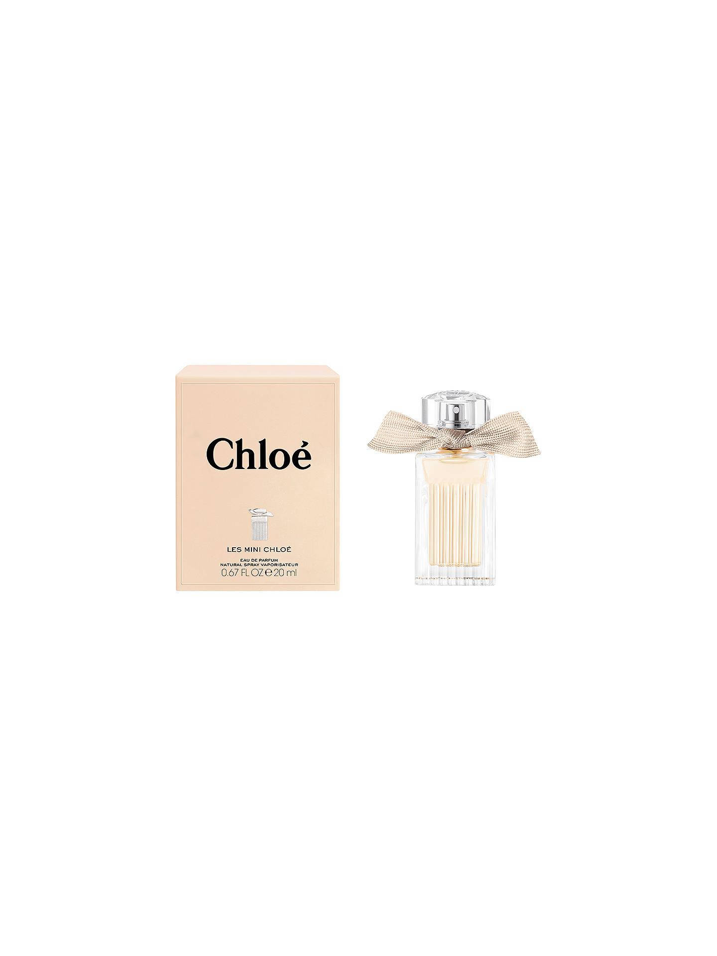 品牌 桌布 壁紙 — 一個極簡風格的產品照片，展示Chloe香水瓶，旁邊有金色蝴蝶結和米色盒子，背景為白色。