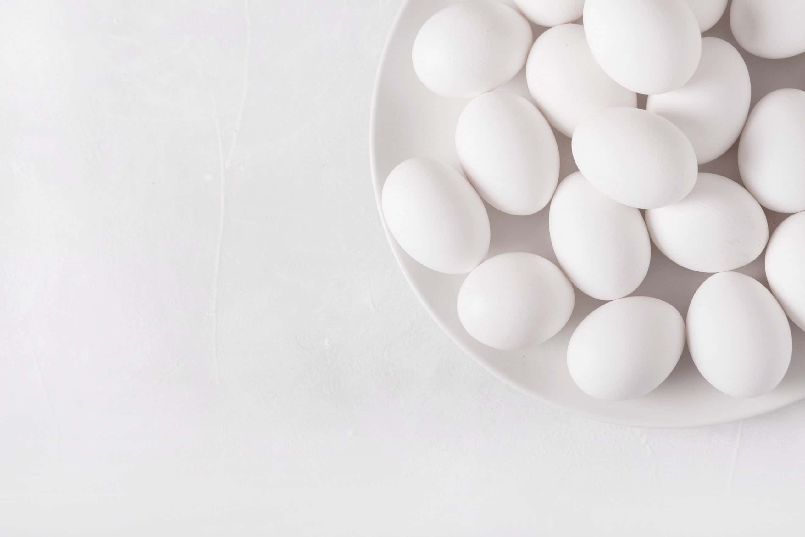 Egg White 桌布 壁紙 — 一個極簡風格的碗，盛著光滑的白蛋，放在柔軟有紋理的白色表面上，光線明亮均勻。