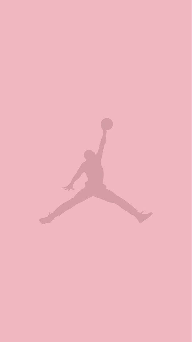 Air Jordan 桌布 壁紙 — 一個極簡風格的籃球運動員剪影，正在半空中灌籃，背景為純粉紅色。