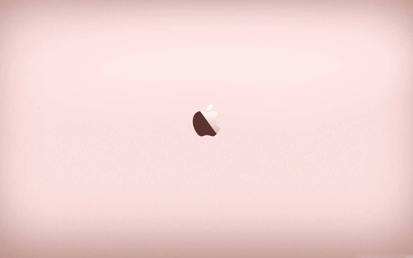Rose Gold Desktop 桌布 壁紙 — 一個極簡風格的粉紅色筆記型電腦蓋，中央的Apple標誌在漸變背景上柔和發光。