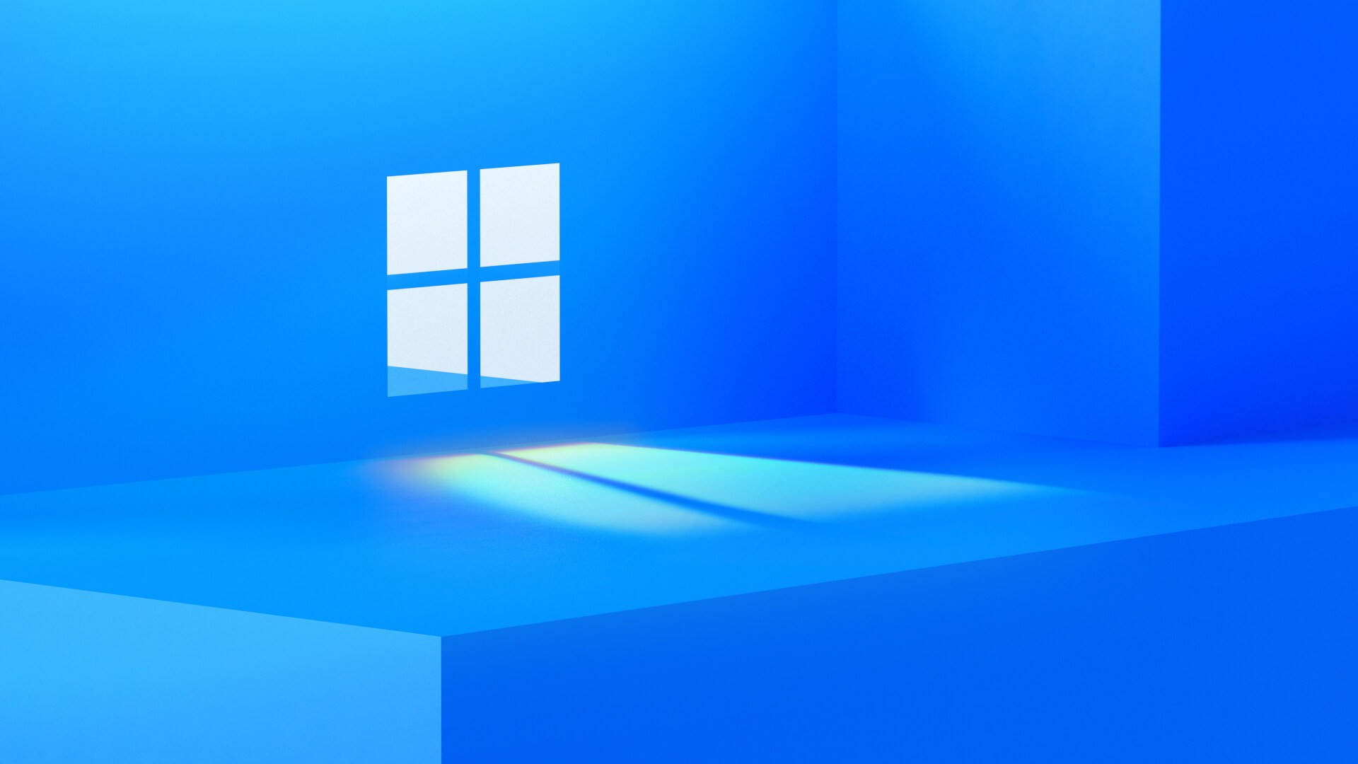 Windows 11 桌布 壁紙 — 一個極簡風格的藍色房間，帶有發光的Windows標誌，在地板上投射出柔和的光線。