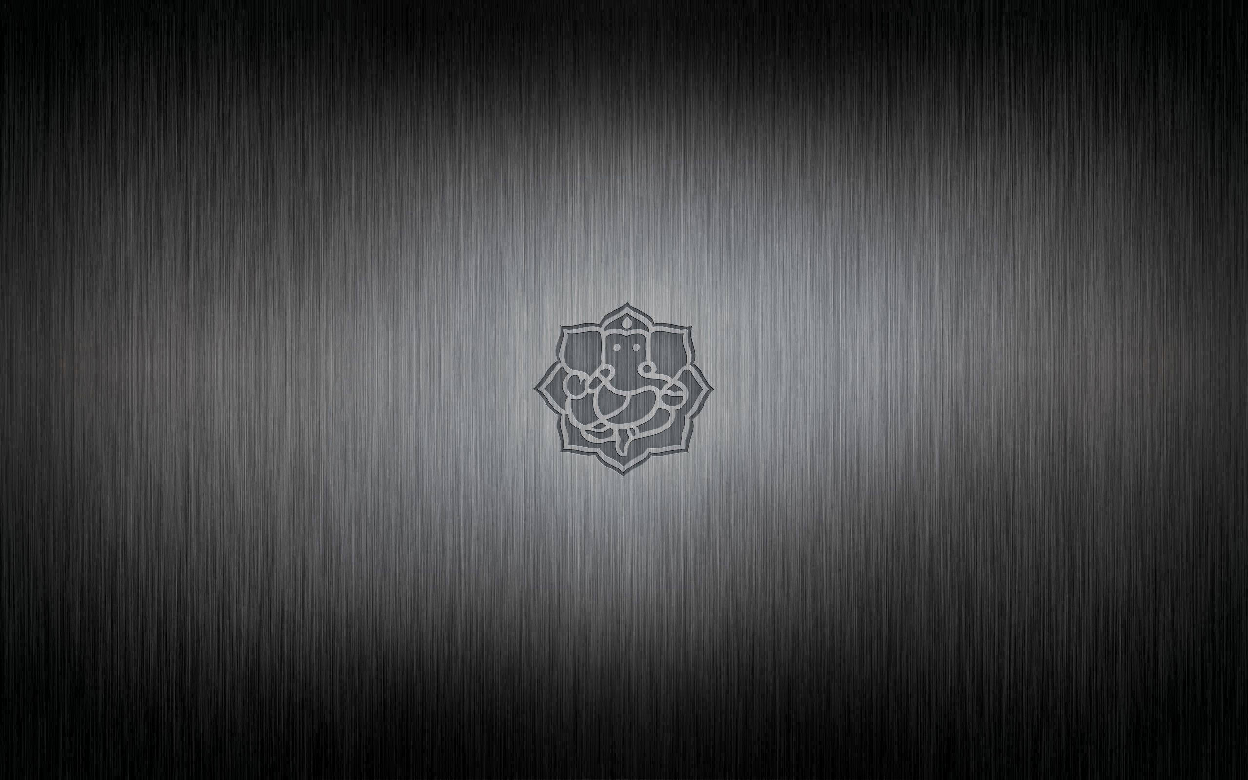 Ganesh 桌布 壁紙 — 一個極簡風格的金屬拉絲鋼背景，中央刻有柔和發光的象頭神符號。