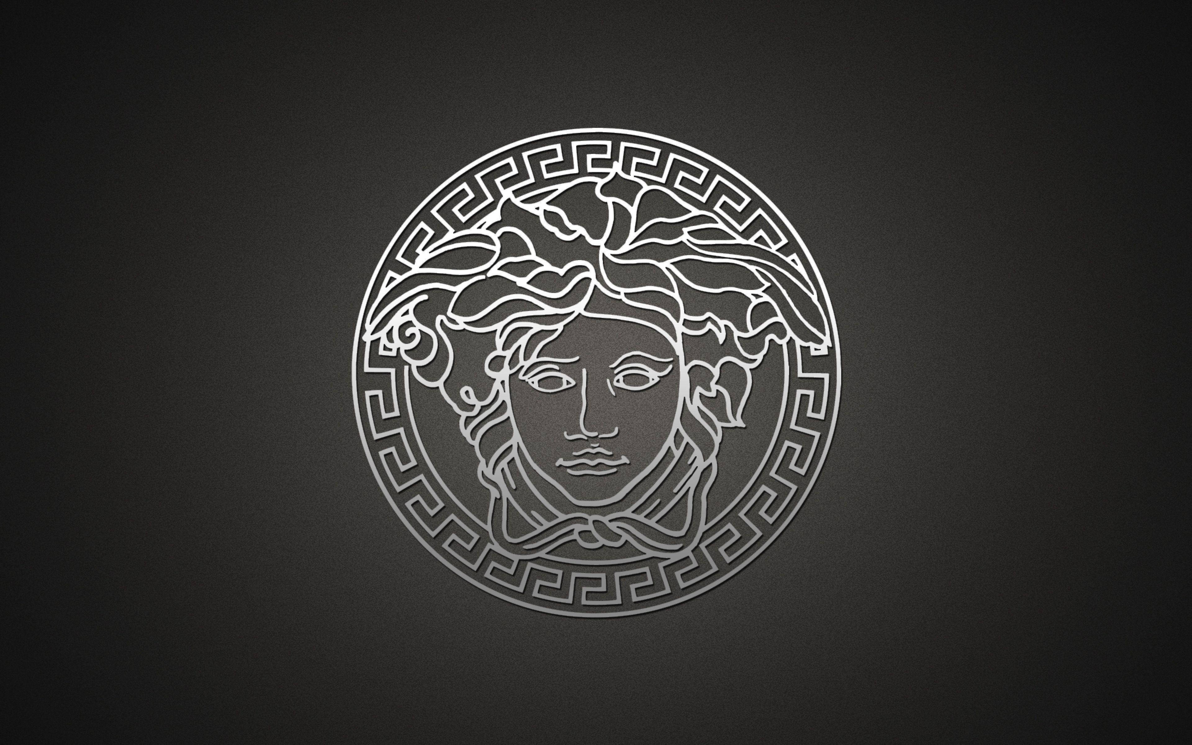 Versace Logo 桌布 壁紙 — 一個極簡風格的銀色美杜莎頭像標誌，帶有希臘鑰匙邊框，居中於深灰色漸變背景上。