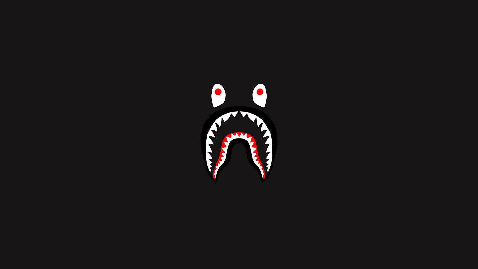 bape logo 桌布 壁紙 — 一個極簡風格的鯊魚臉，紅色眼睛和鋒利牙齒，居中在純黑色背景上。