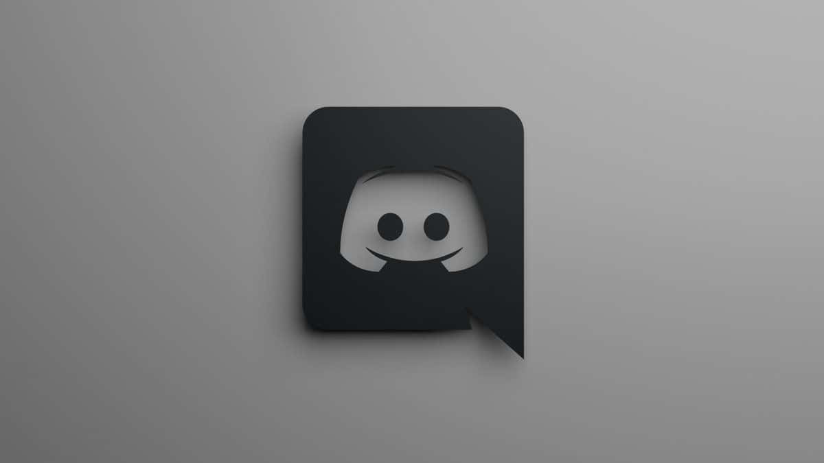 Discord 桌布 壁紙 — 一個極簡風格的黑色 Discord 標誌，中央有一個微笑的鬼臉，背景為柔和的灰色漸變。