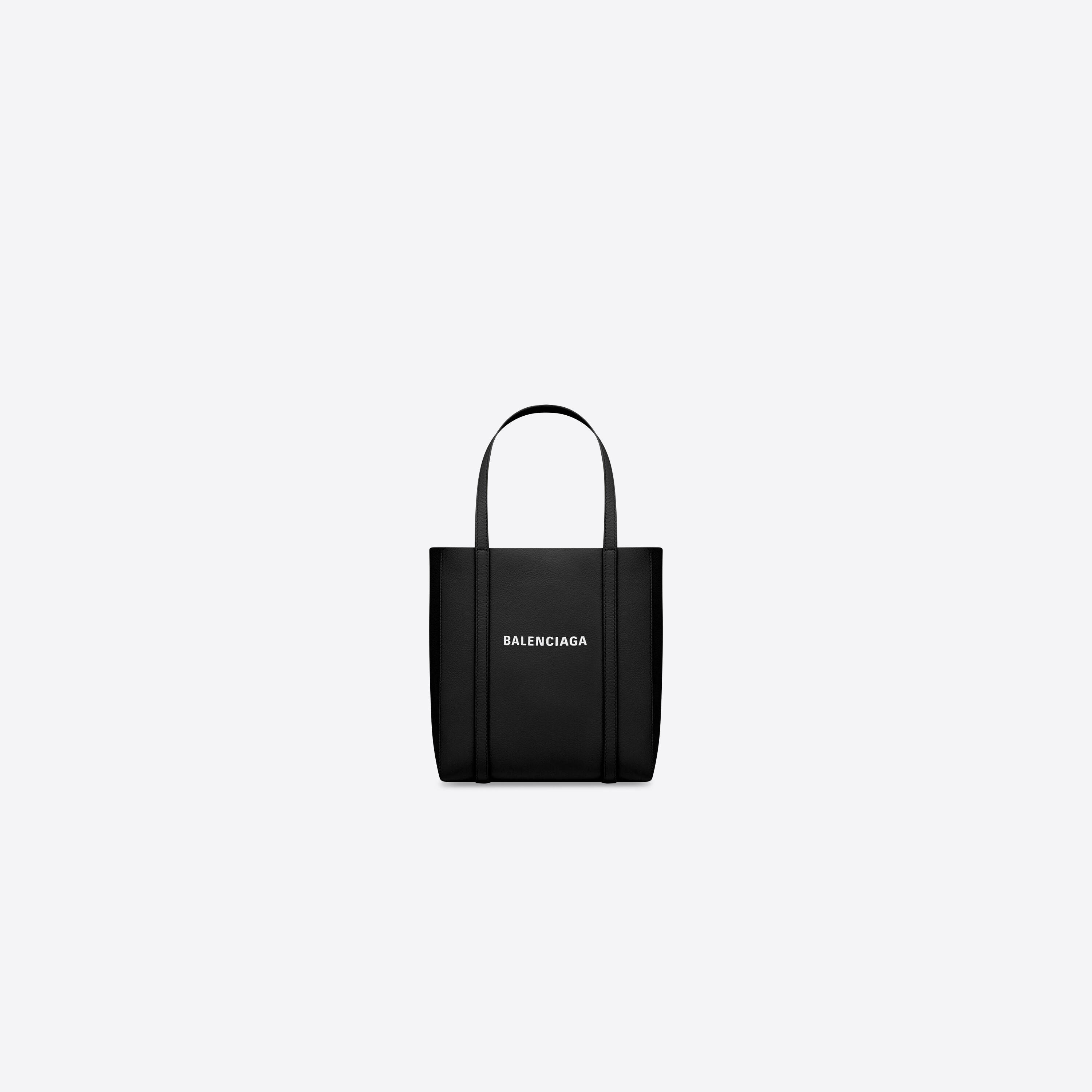 Balenciaga 桌布 壁紙 — 一個極簡風格的黑色Balenciaga托特包，帶有白色標誌，居中放置在純淺灰色背景上。