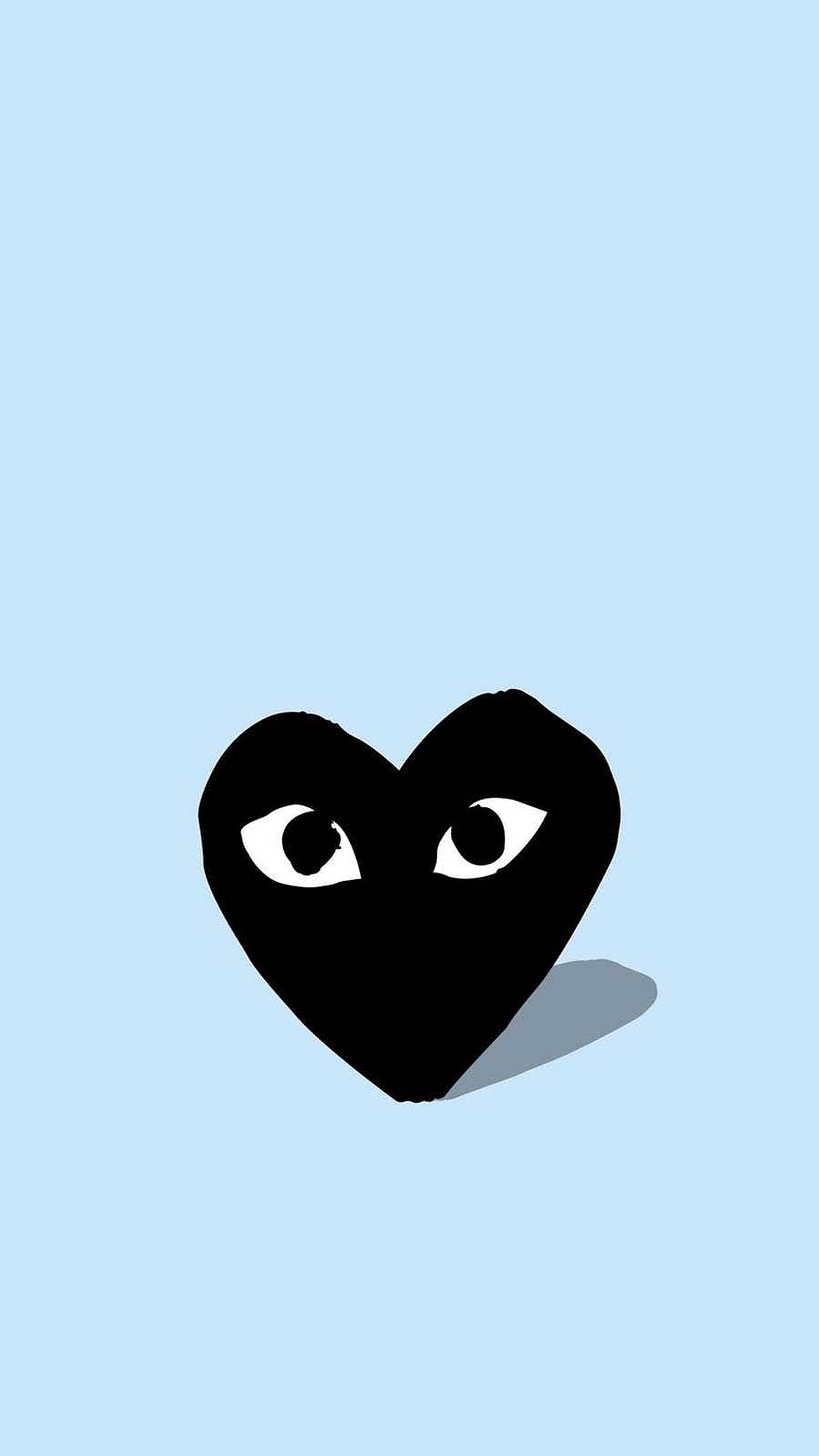 cdg 桌布 壁紙 — 一個極簡風格的黑色心形，帶有白色眼睛，在柔和的藍色背景上凝視，投下微妙的陰影。