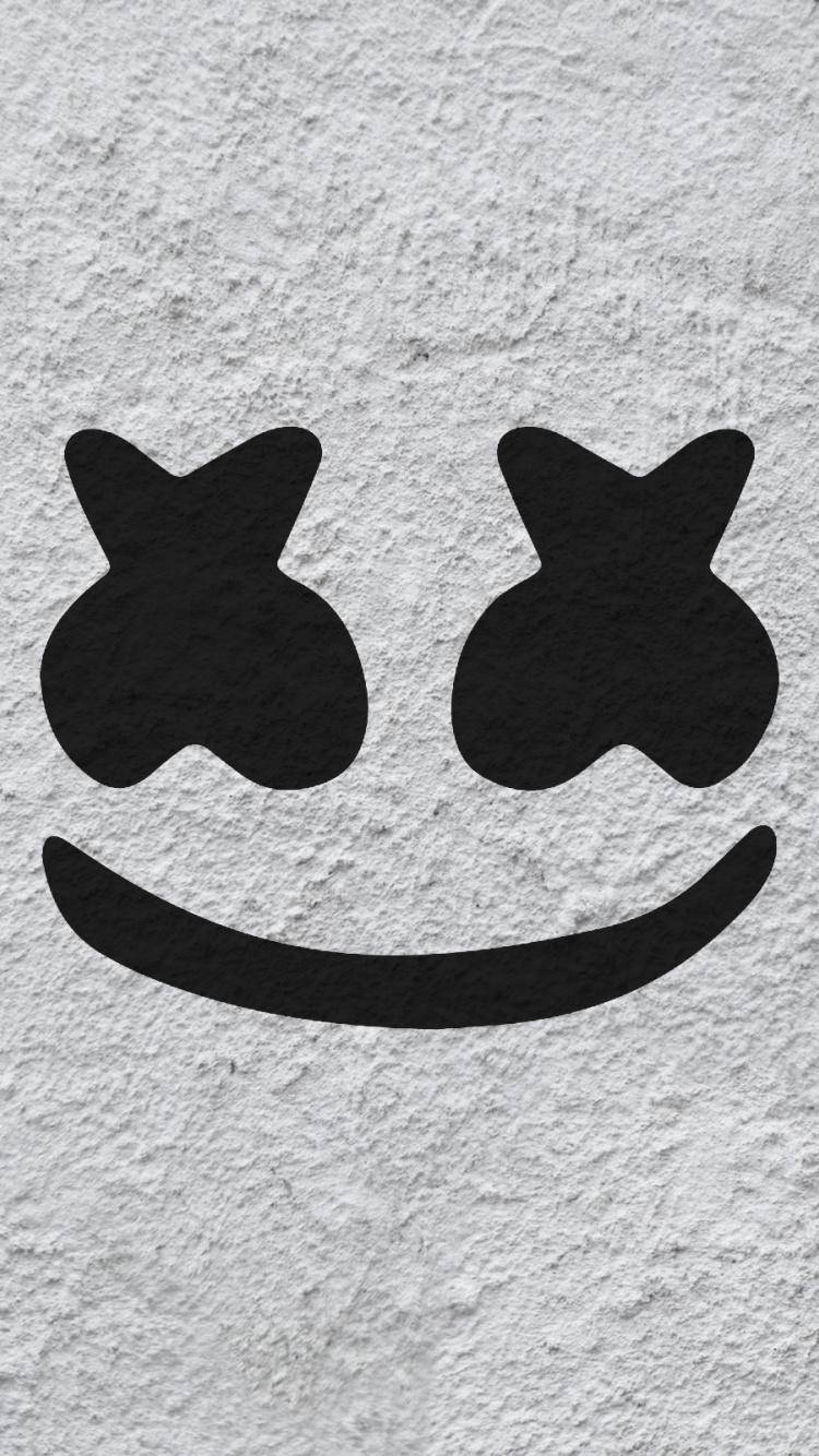 marshmello iPhone 桌布 壁紙 — 一個極簡風格的黑色笑臉，帶有X形眼睛，畫在粗糙的白色紋理牆上。