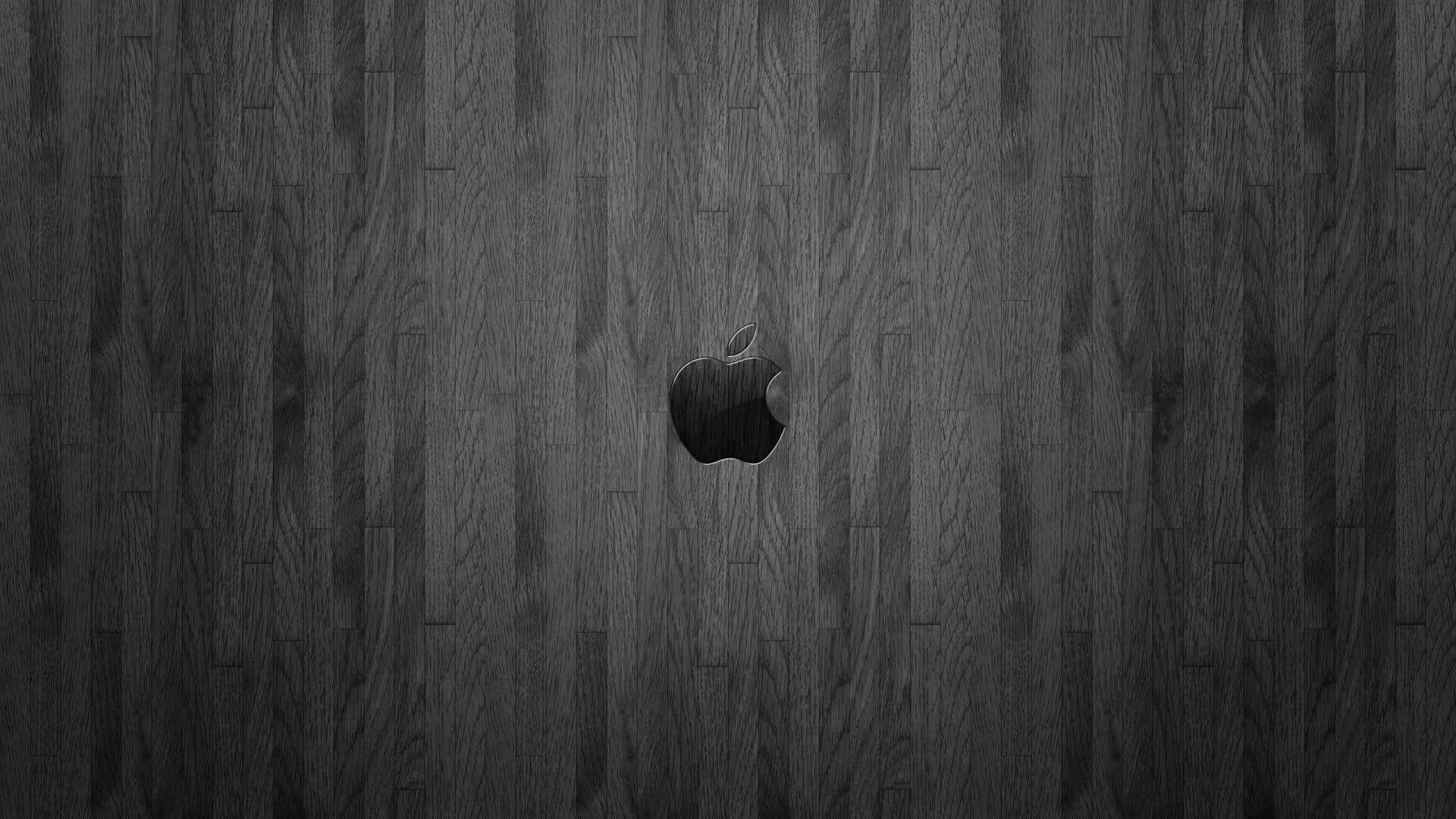 1920x1080 Apple 桌布 壁紙 — 一個極簡風格的黑色蘋果標誌，居中放置在帶有細微木紋圖案的深色紋理木質表面上。