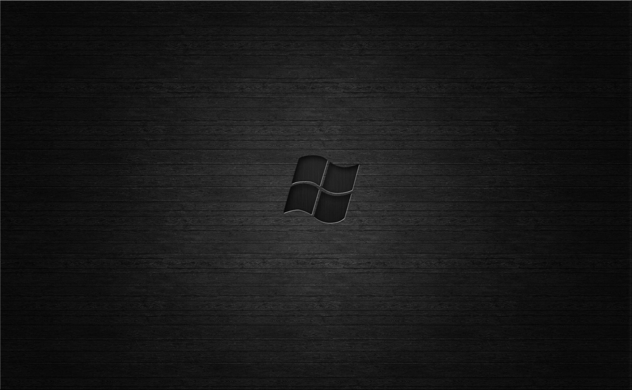 Dark Windows 桌布 壁紙 — 一個極簡黑色Windows標誌居中於深色紋理木質表面，帶有柔和燈光。
