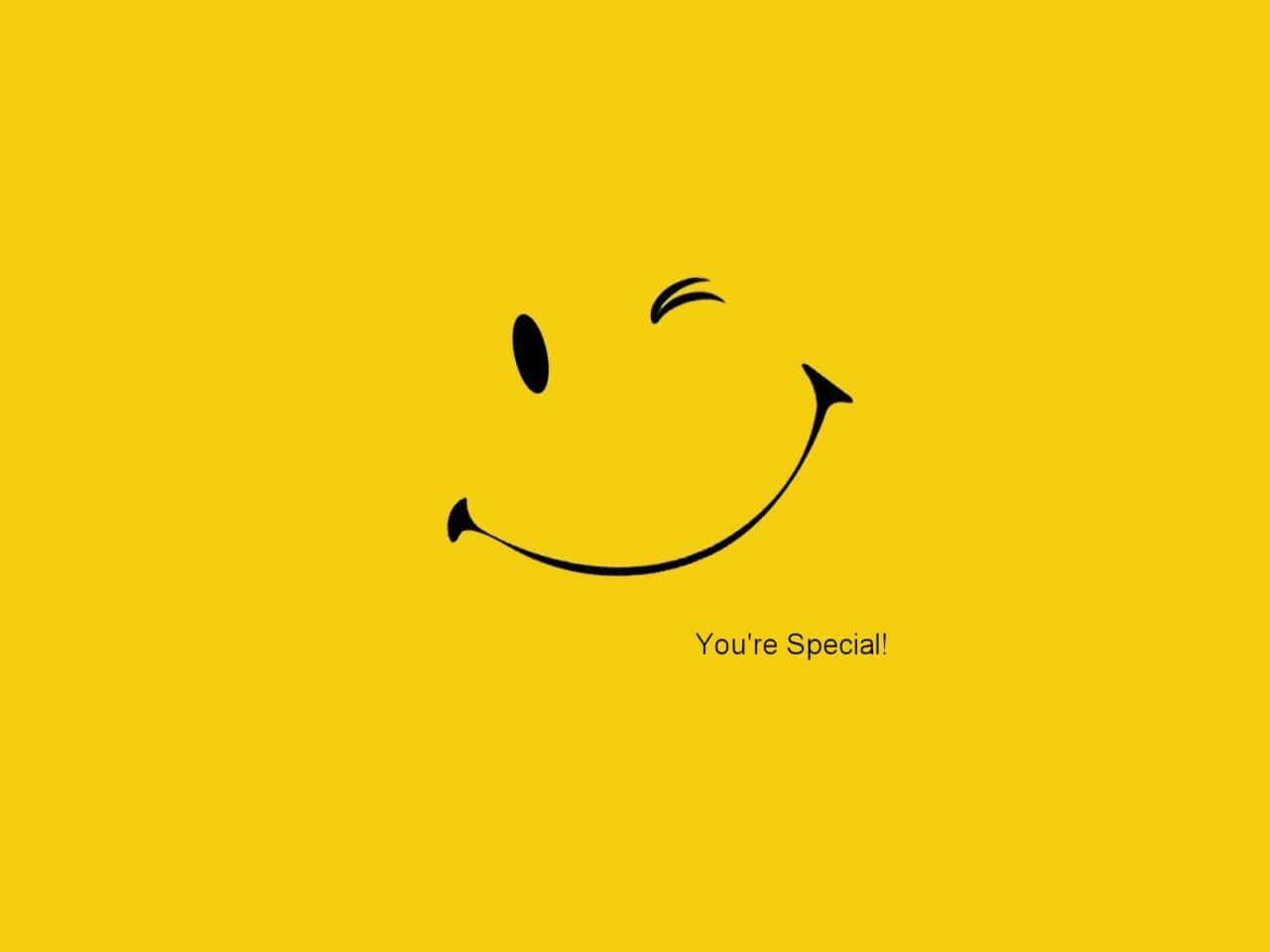 Smiley 桌布 壁紙 — 一個極簡黑色笑臉在純黃色背景上眨眼，並帶有文字「你很特別！」